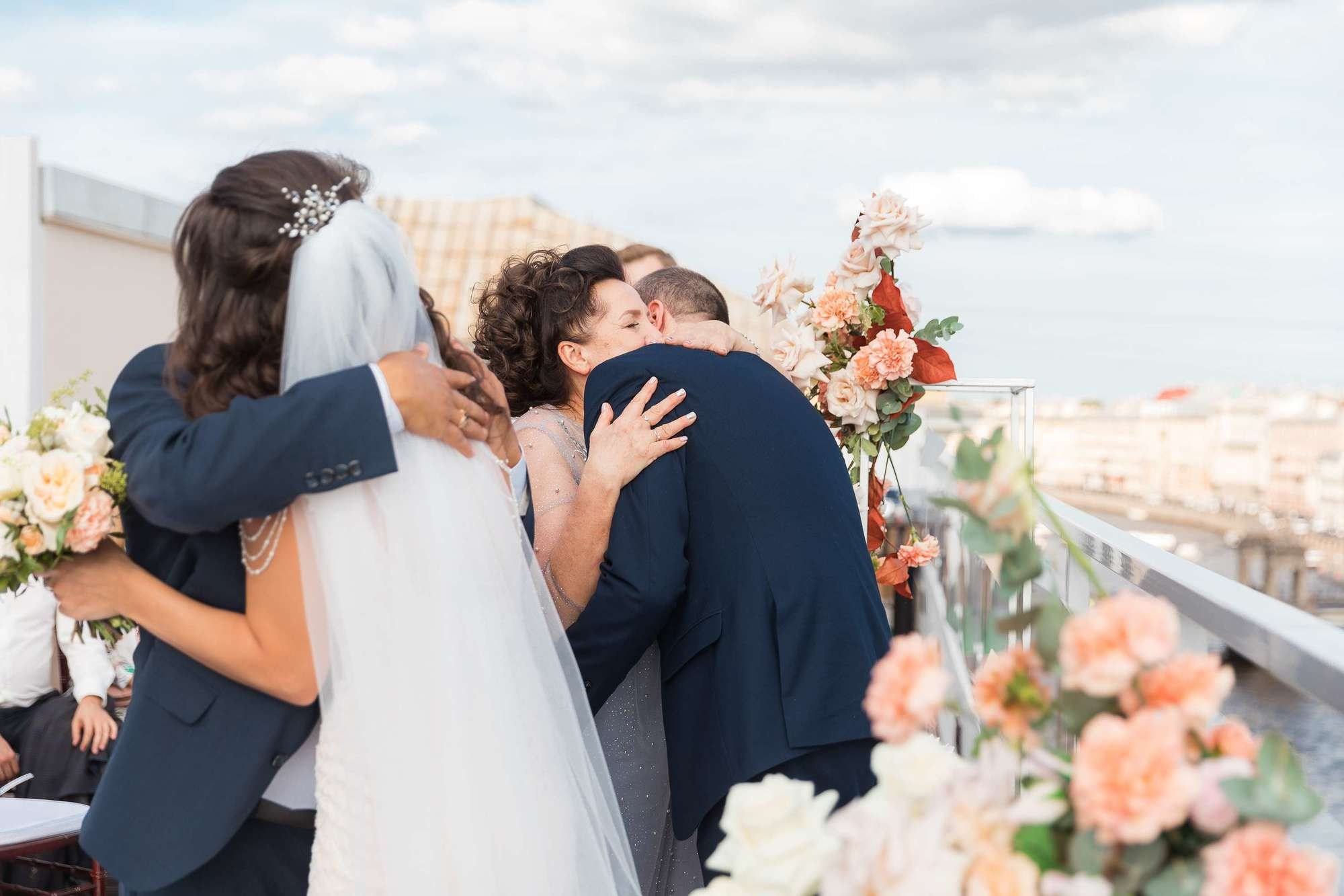 Молодоженов обнимают родители