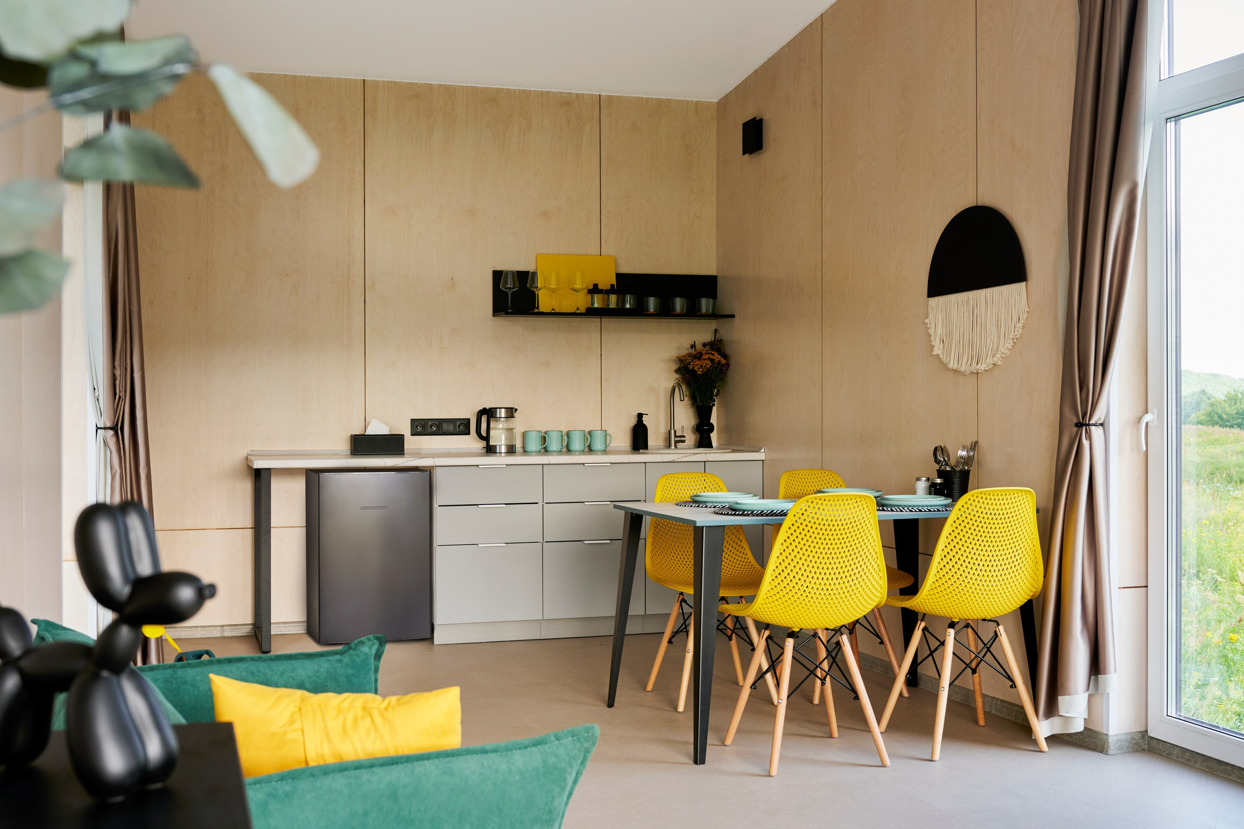 Кухонный блок, жёлтые стулья, аккуратные фасады и свет