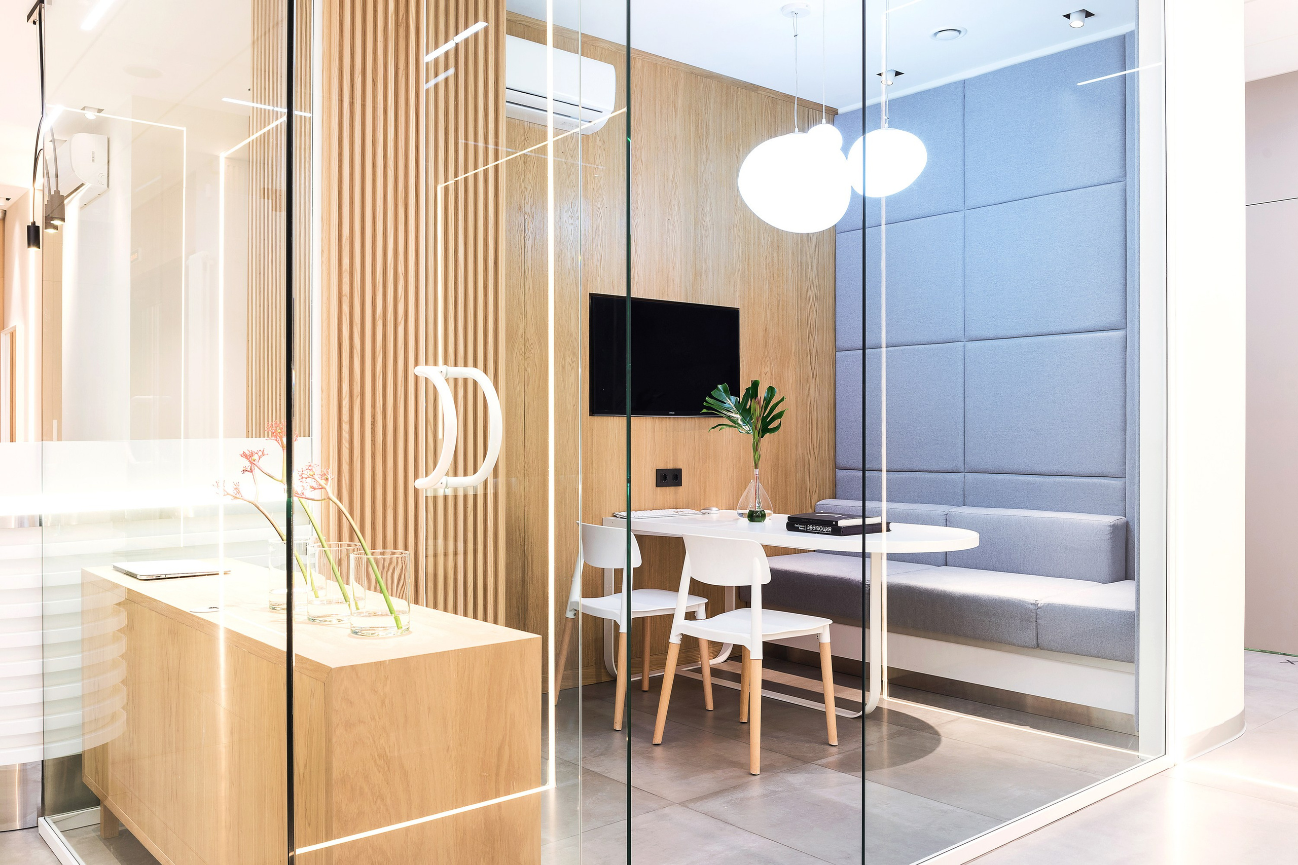 дизайн интерьера стоматологической клиники выполнен в современном минималистичном стиле с теплой домашней атмосферой. Текстуры дерева, наливной пол, яркие акценты, чистота линий, модульная сетка, стеклянные перегородки