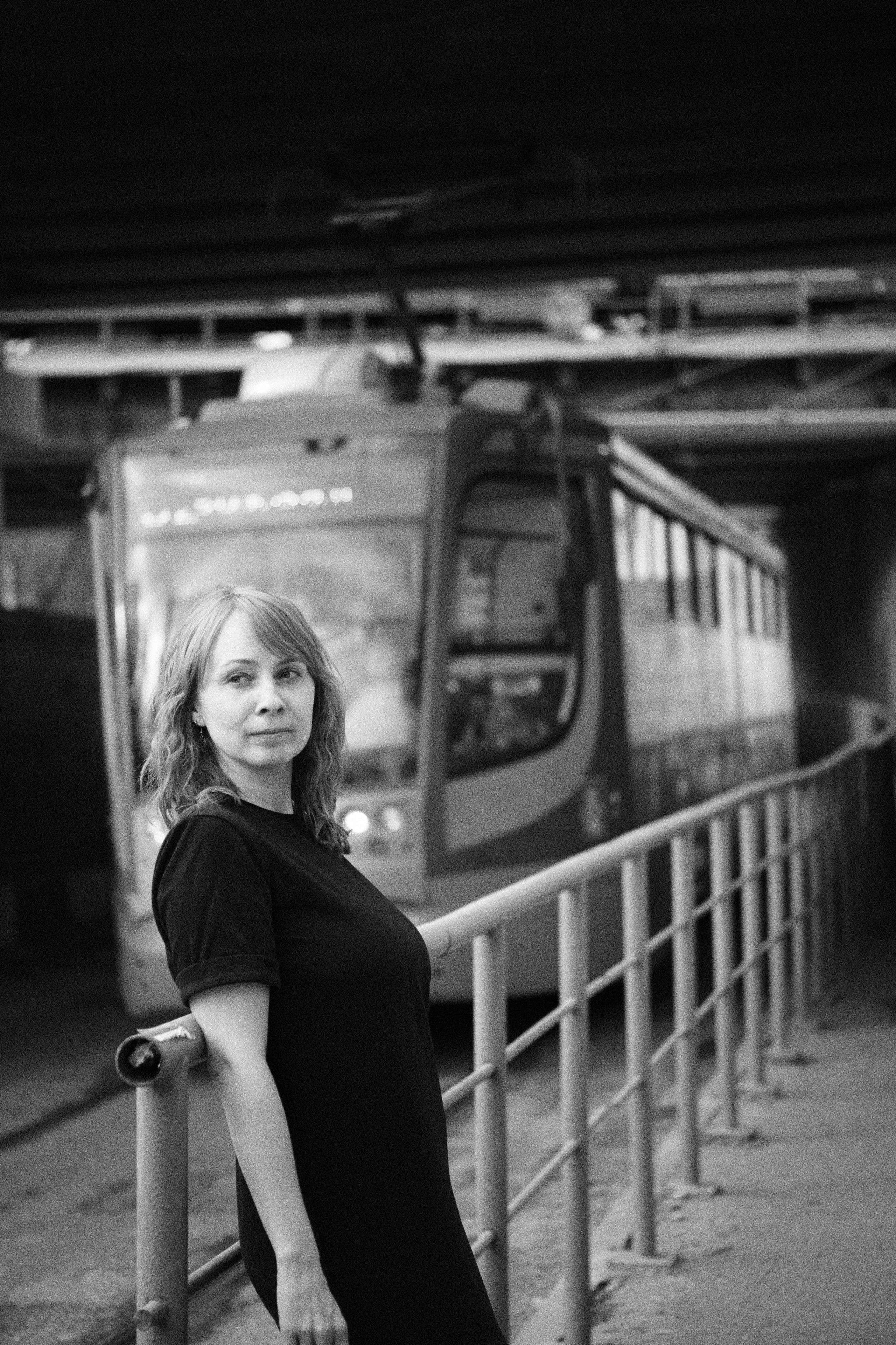 женщина стоит на фоне движущегося трамвая