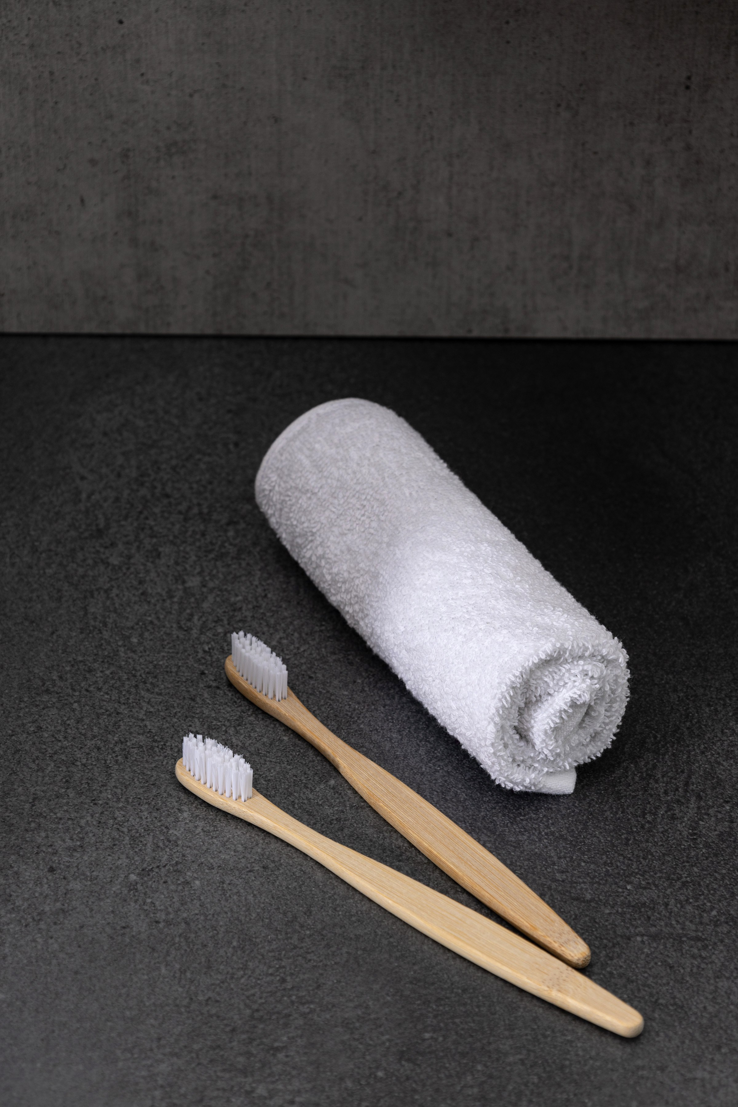 Свернутое белое полотенце с зубными щетками в ванной | Интерьерная съемка для каталога