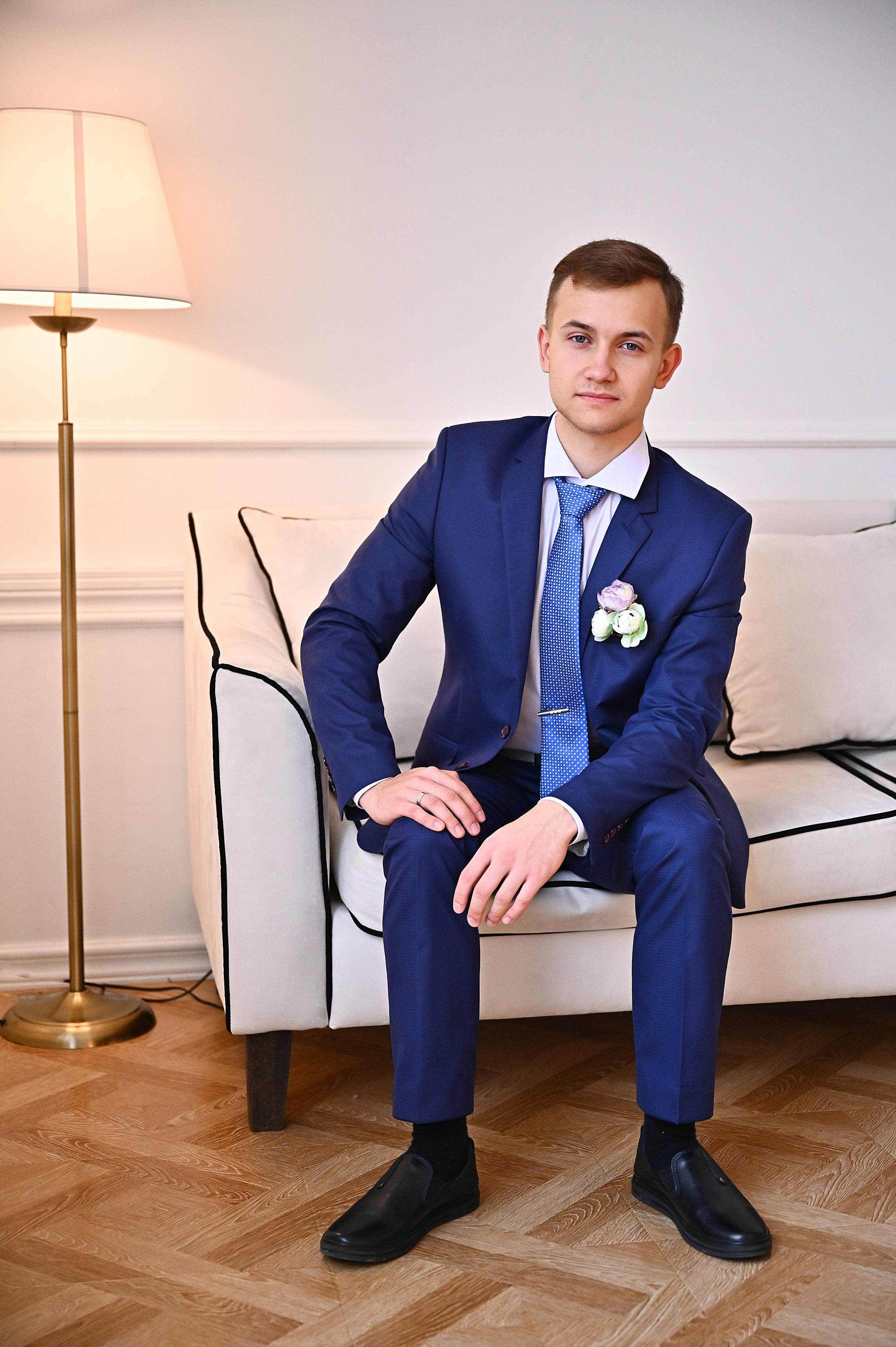 Жених в синем костюме на белом диване с торшеромв Краснодаре