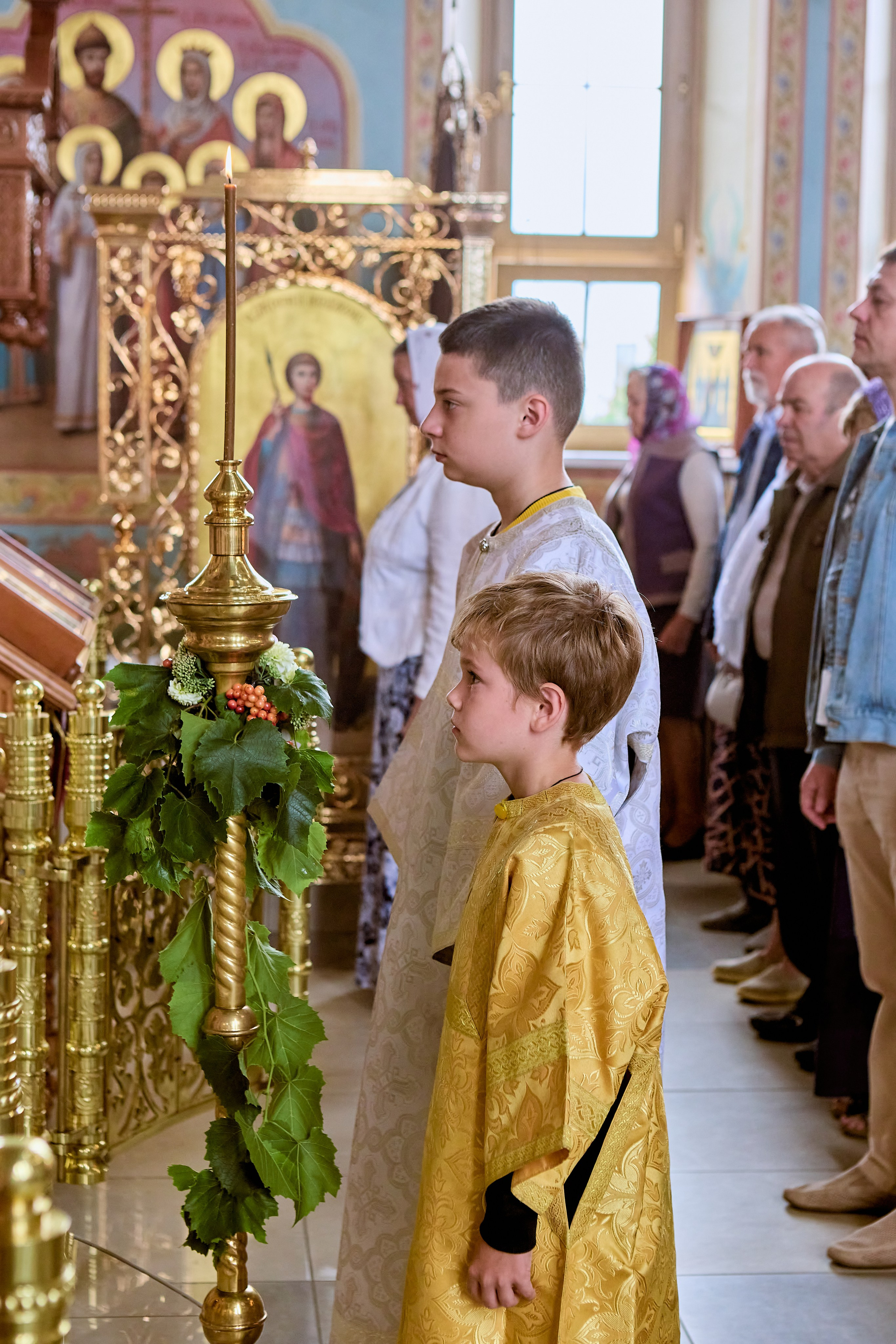фотография алтарников у свечи на чтении Святаго писания Евангелия в праздник Преображения Господа Бога и Спаса нашего Иисуса Христа