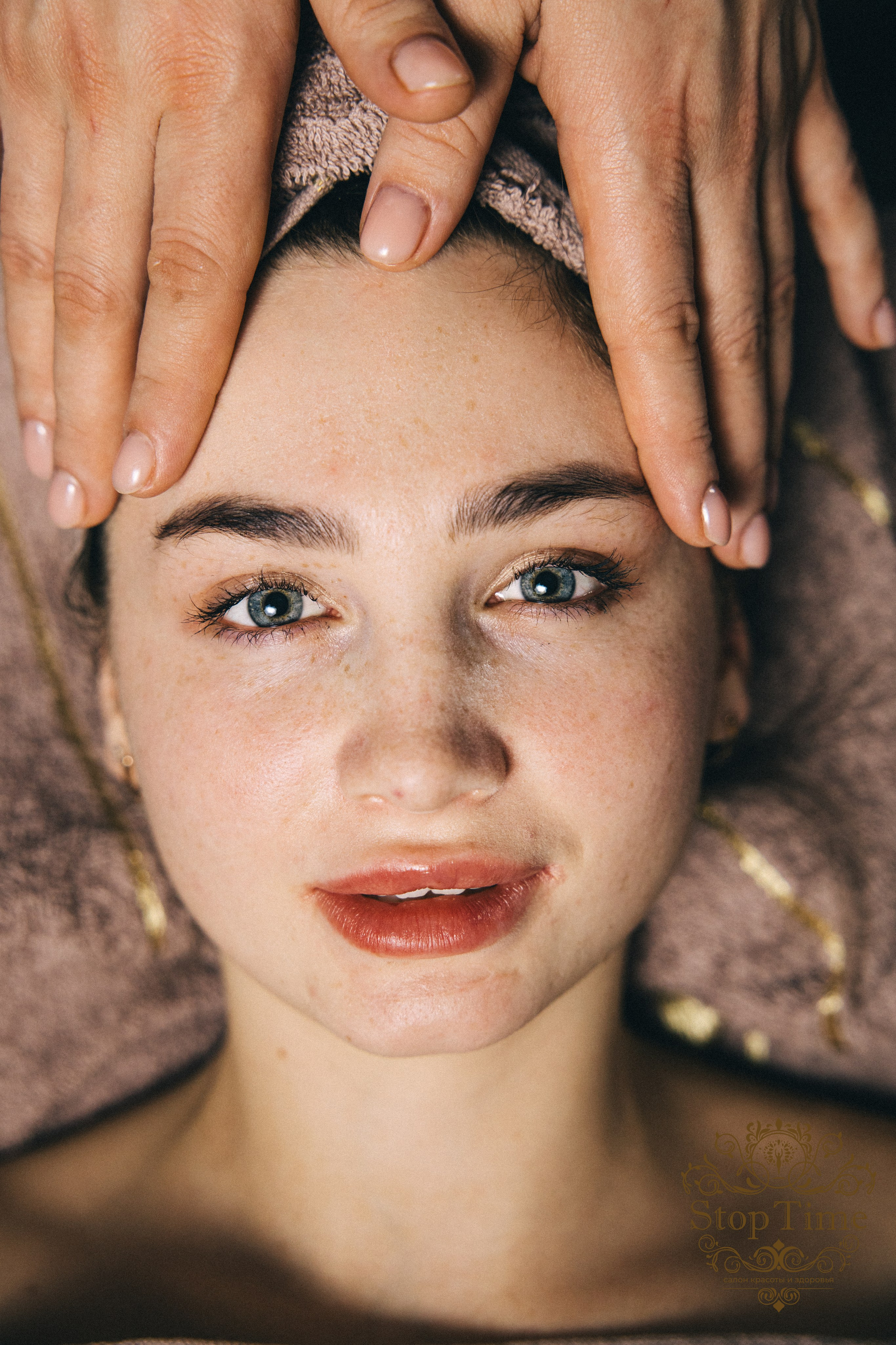 девушка смотрит в камеру когда делают массаж