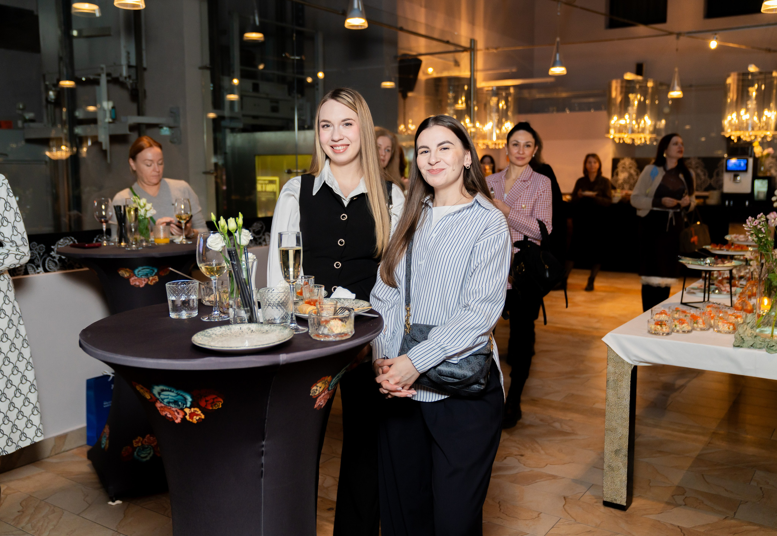 Две стильные женщины за столом на мероприятии в Radisson Sonya Hotel. Фото Евгения Мальцева.