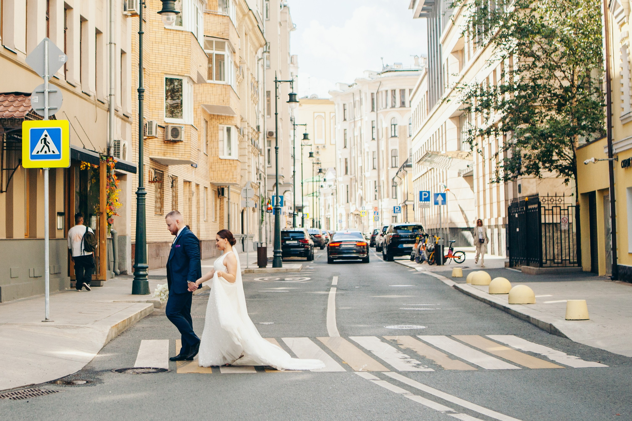 муж и жена идут по пешеходному переходу в центре москвы