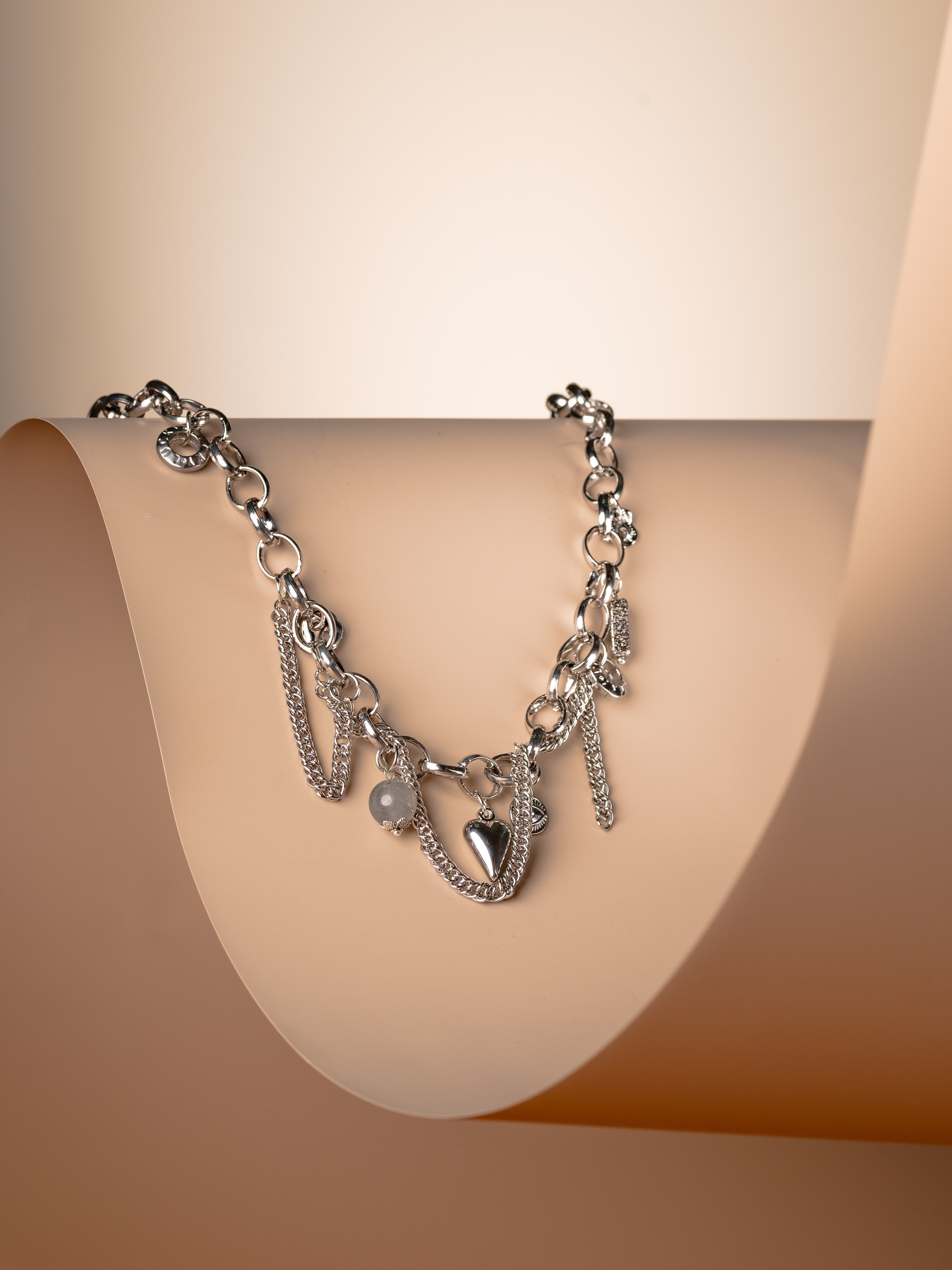 современное ожерелье из медицинской стали с натуральным лабродоритом на кремовом фоне с красивым изгибом