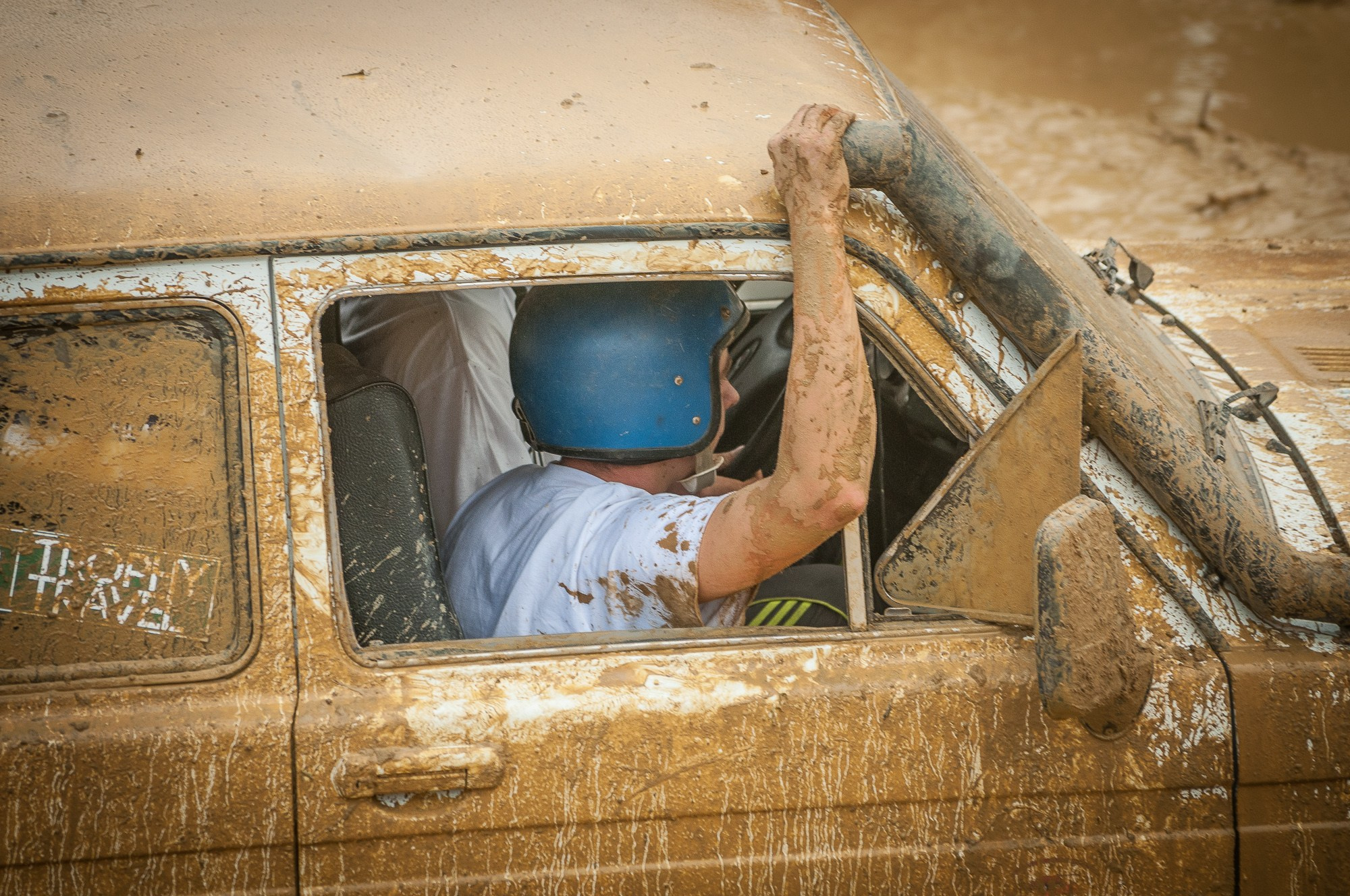 Штурман гоночного автомобиля держится за крышу 