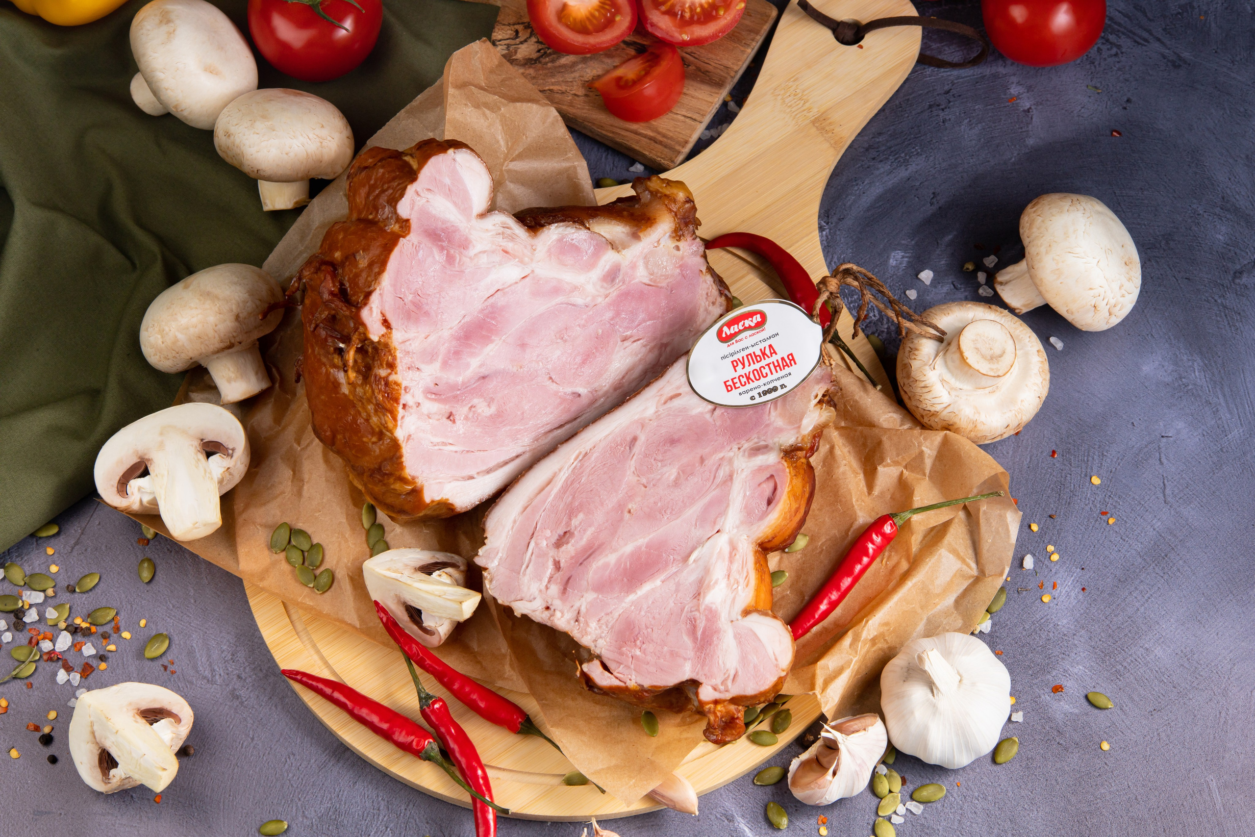 Разрезанная свиная рулька с грибами и помидорами