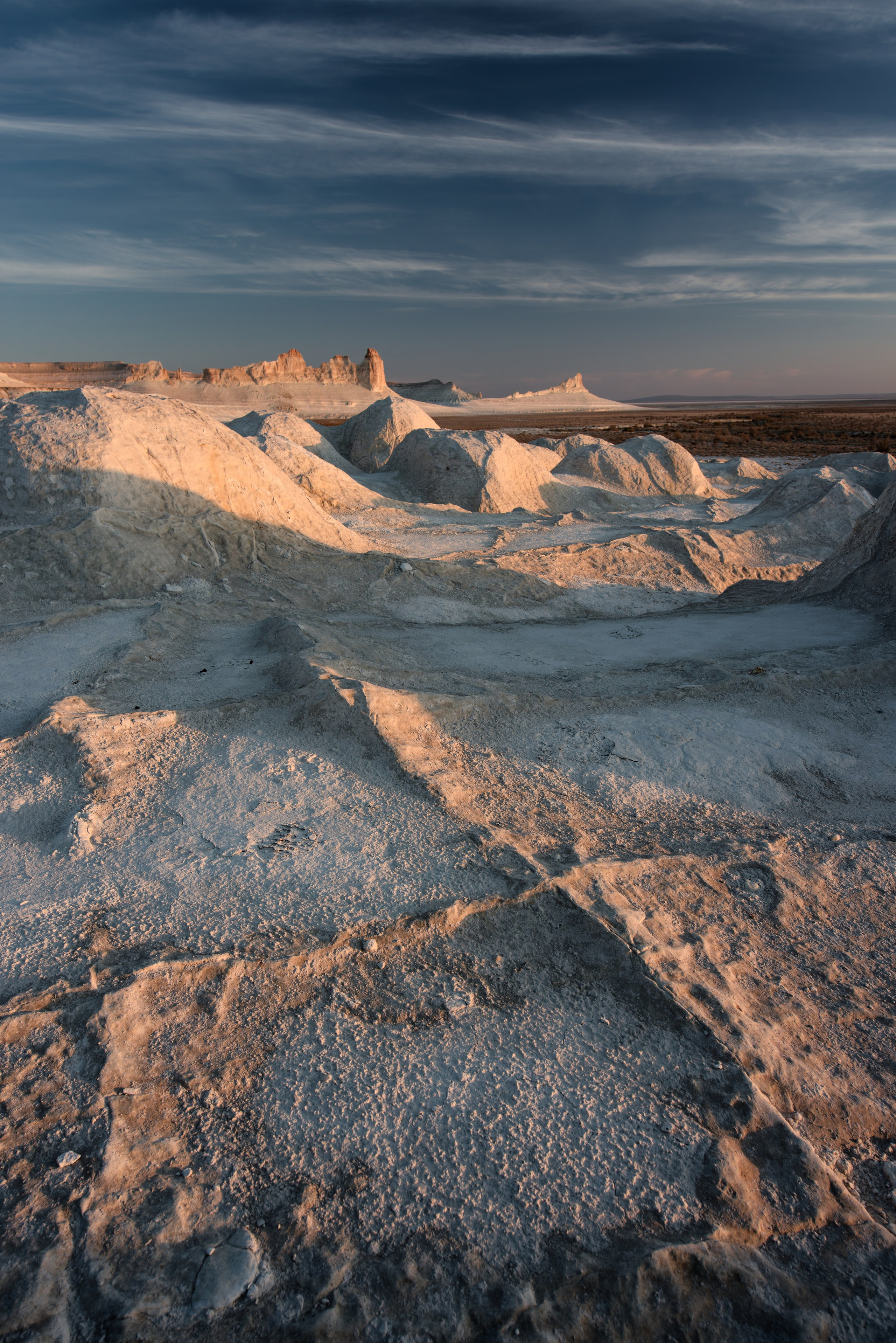 Трещины на переднем плане и Бозжира на заднем на закате