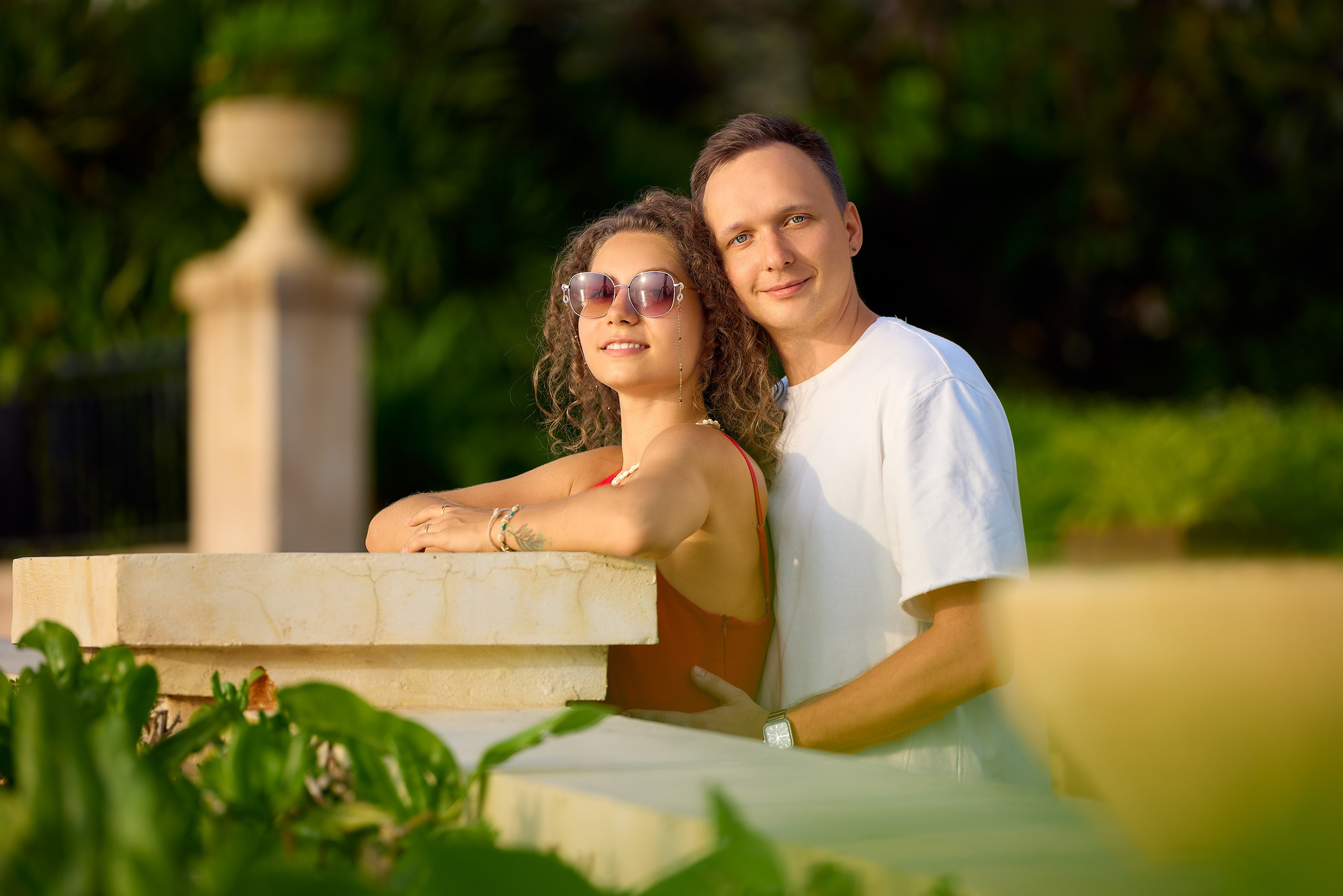 Close‑up portrait of a couple with creamy bokeh in warm sunset light, captured by the on‑site photographer during a couples photoshoot; romantic mood, Sunset Town, Phu Quoc, Vietnam.