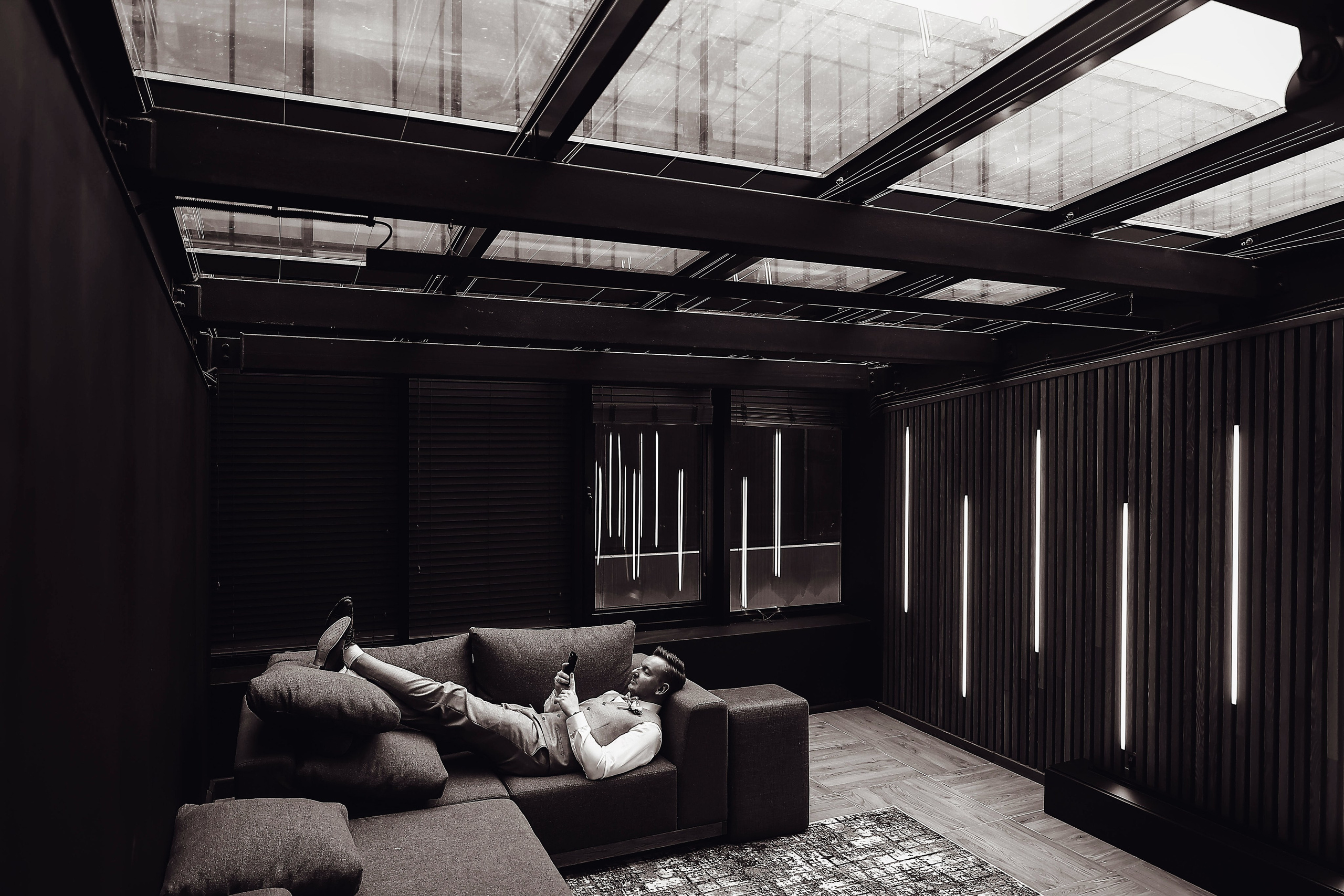 Жених лежит на диване в интерьере отеля Мариотт. Фотограф Денис Перминов