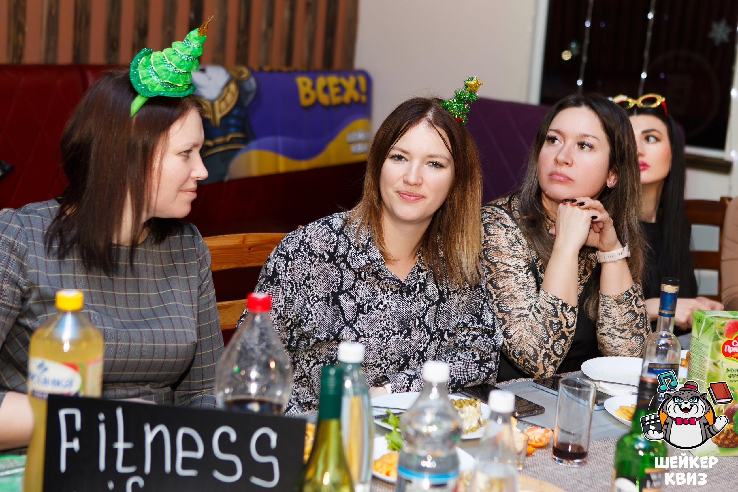 Фотосессия новогоднего квиза: команда в праздничных костюмах обсуждает задание