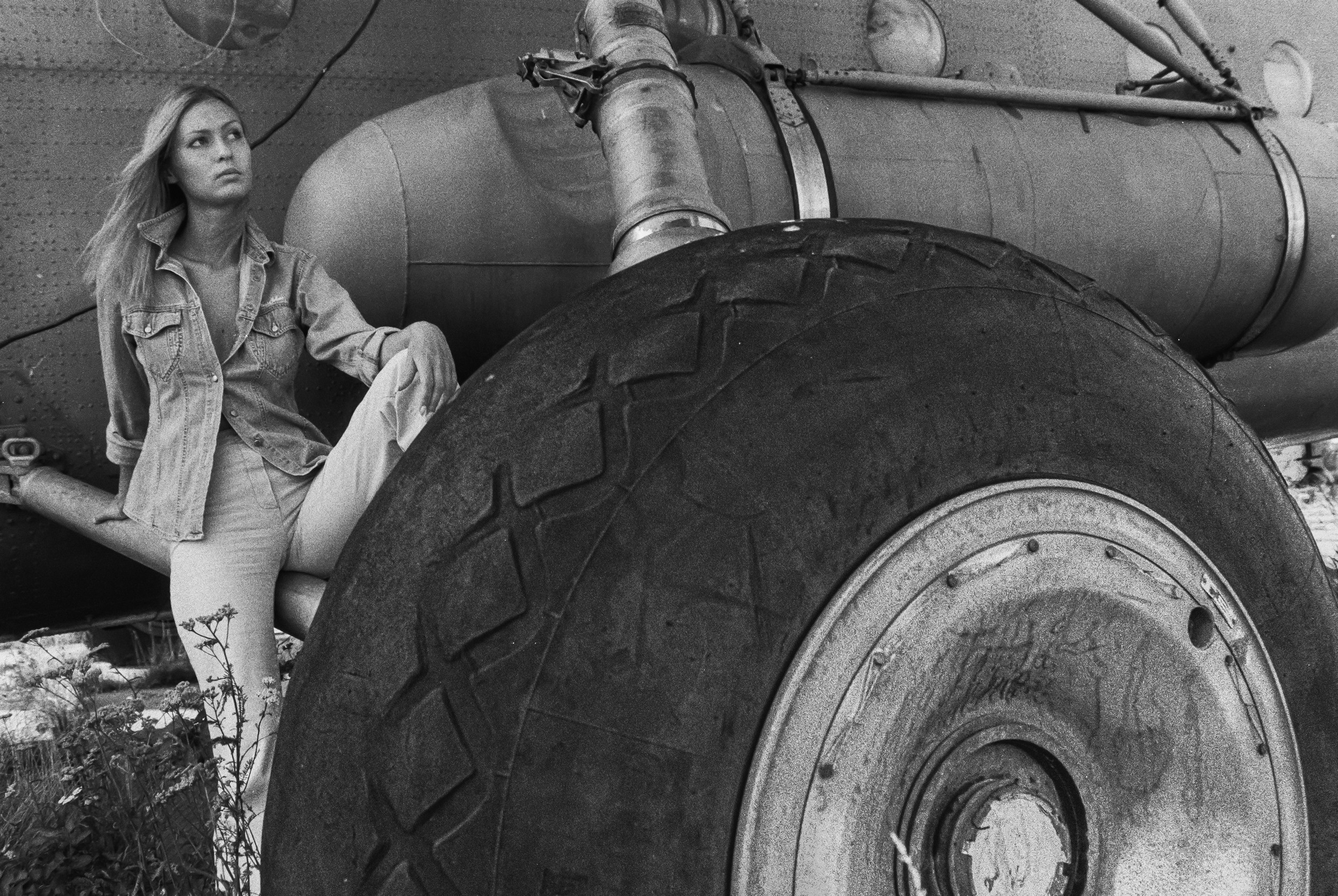 Девушка возле огромного колеса вертолёта.