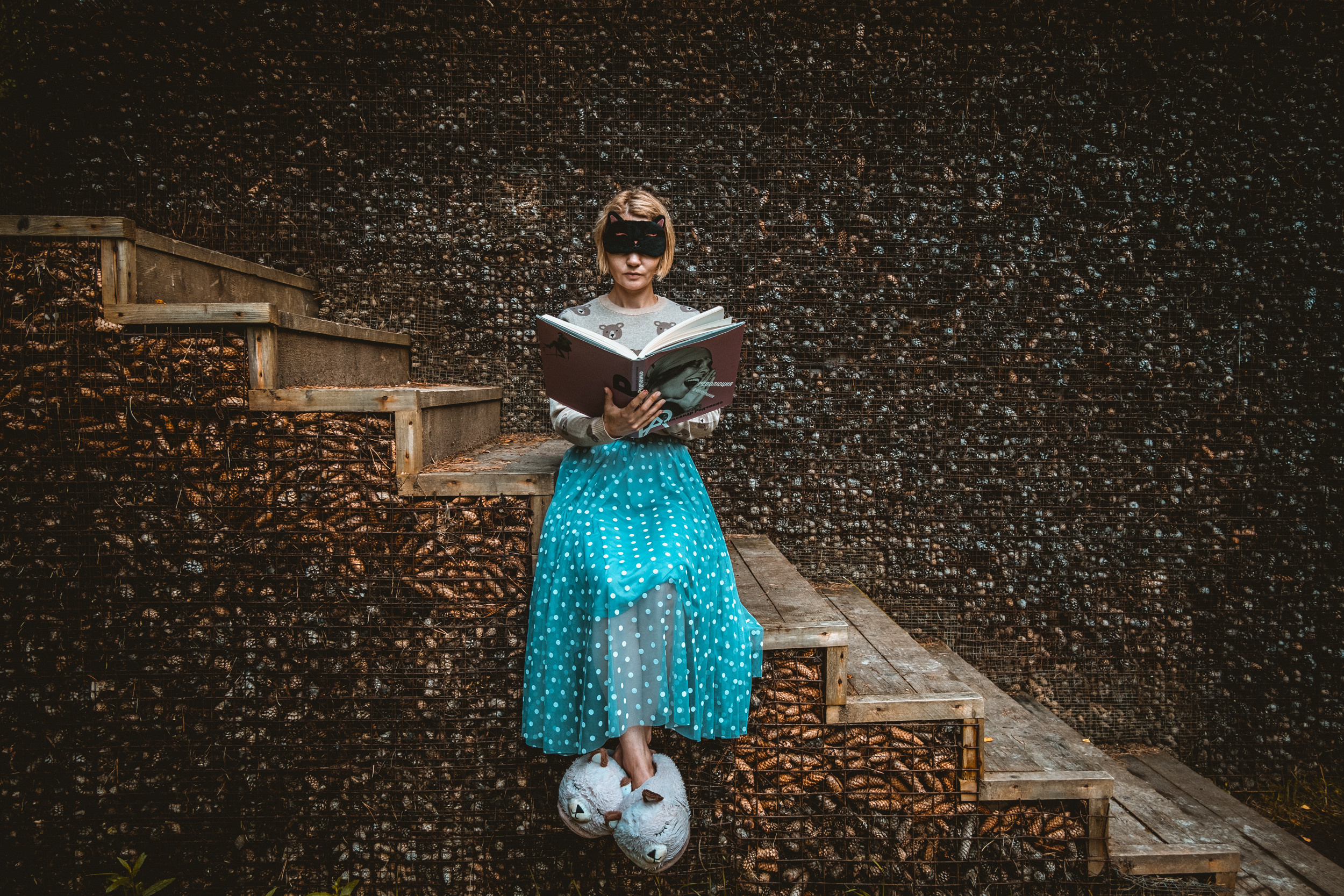 Фотоискусство. Девушка на ступеньках читает книжку. Необычный фон.