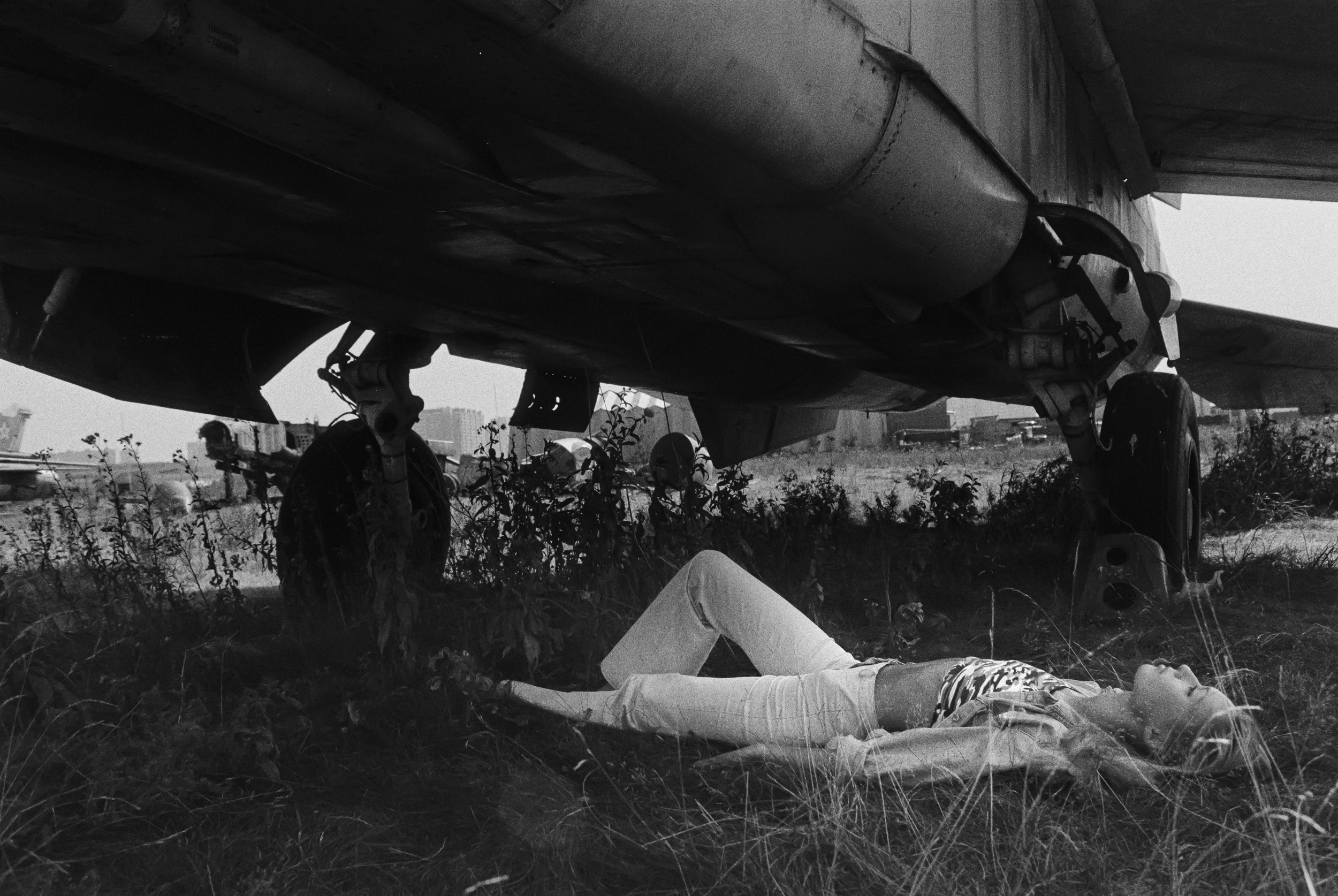 Девушка лежит у самолета.