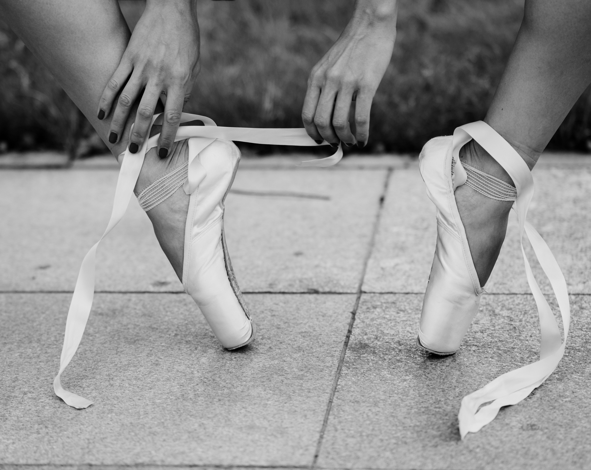 Балерина завязывает пуанты.