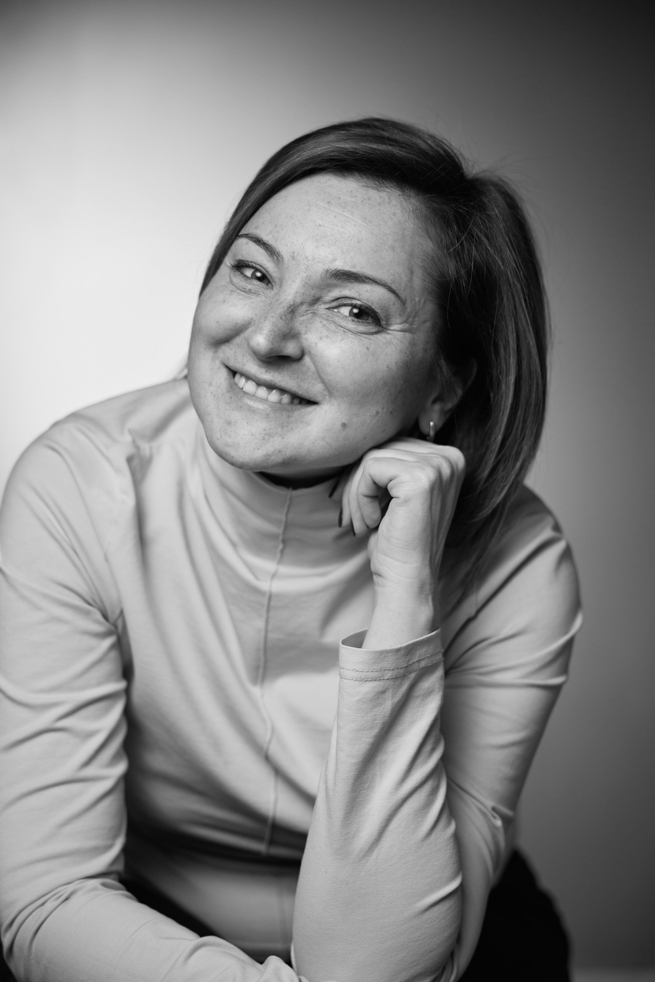 Black and white emotional portrait of a young woman against a grey studio background - photographer Andrey Dunin