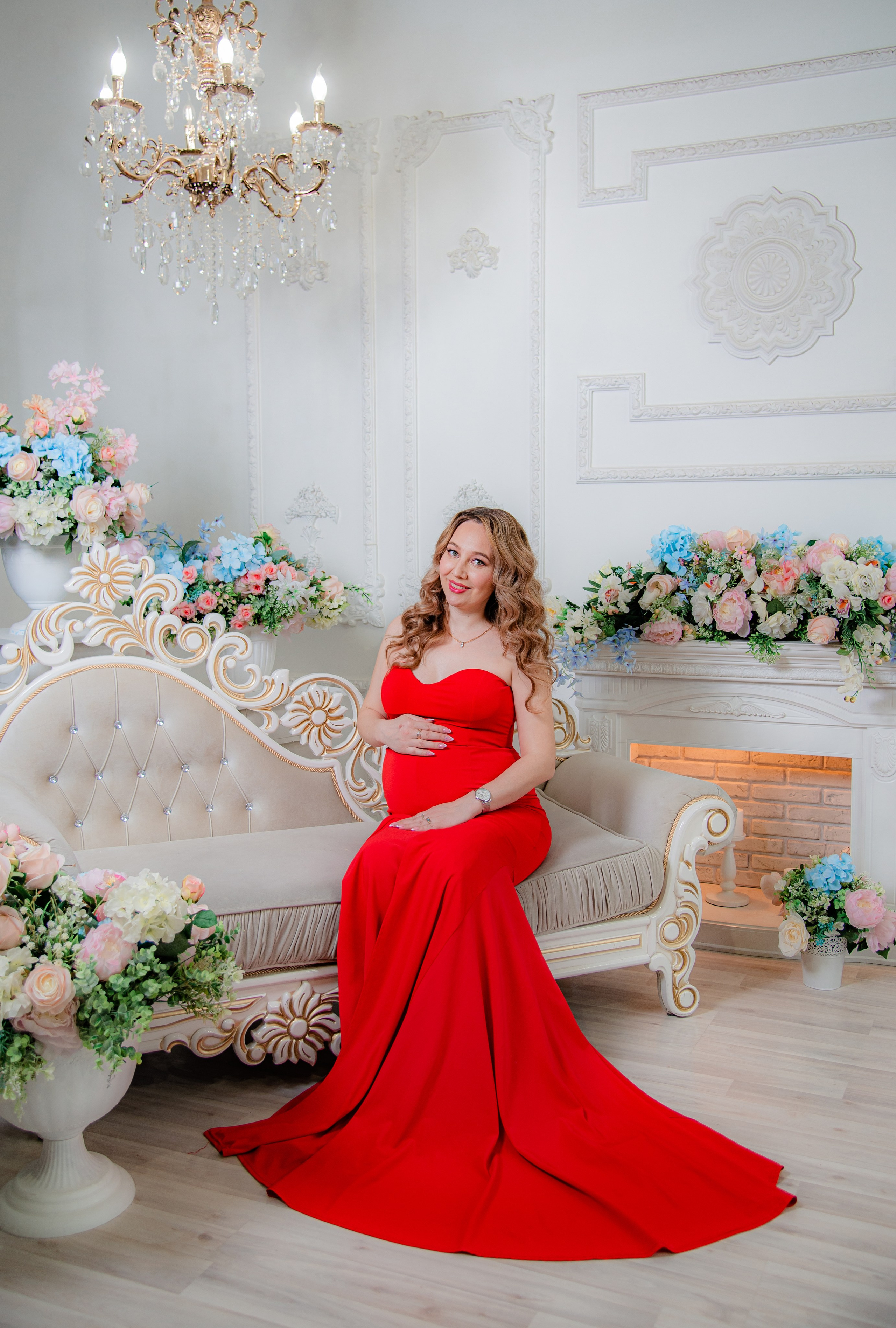 Фотосессия беременных в фотостудии в Уфе: будущая мама в элегантном платье из проката, с профессиональным макияжем и прической. Она счастливо позирует на фоне стильного интерьера, отражая красоту и нежность материнства.