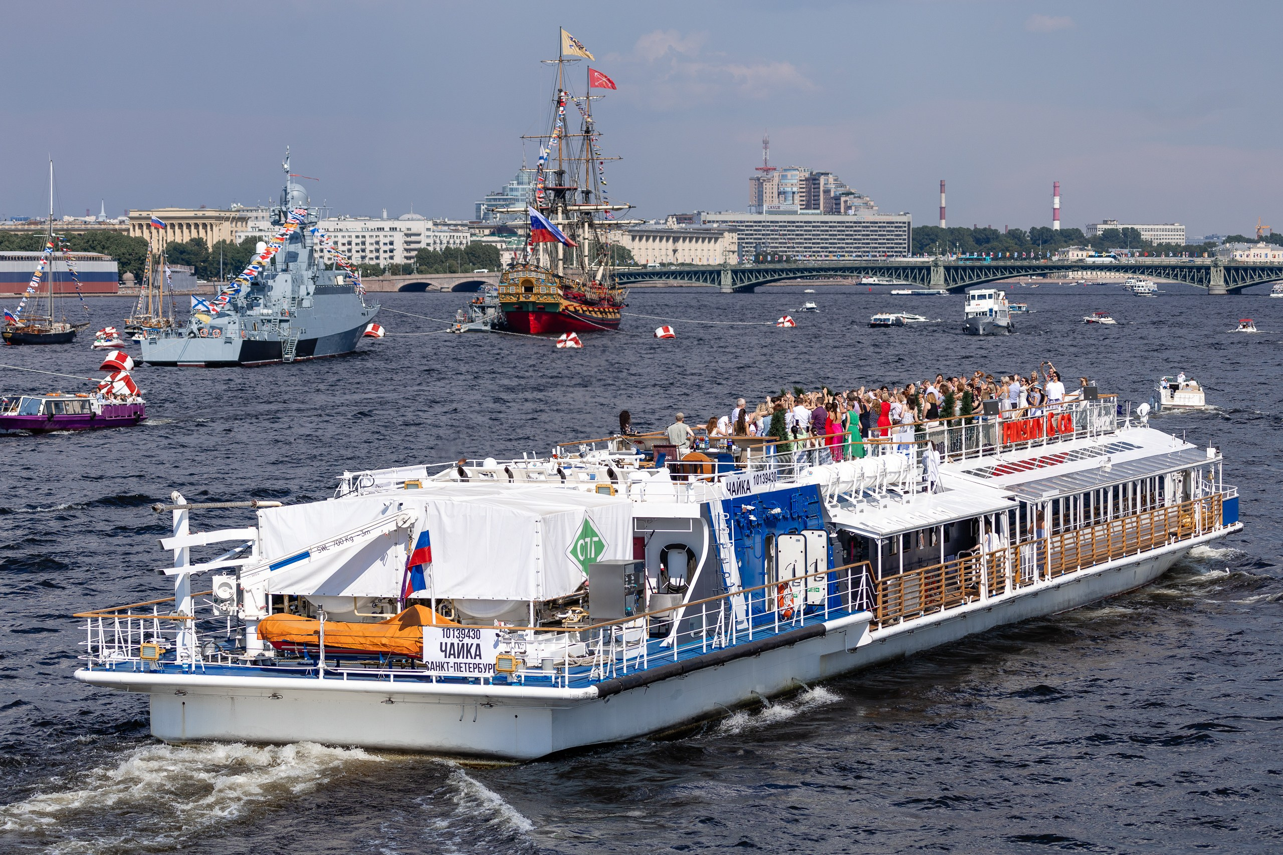 Красивый вид с Дворцовой набережной на Неву с кораблями в День ВМФ России 2024 в Санкт-Петербурге