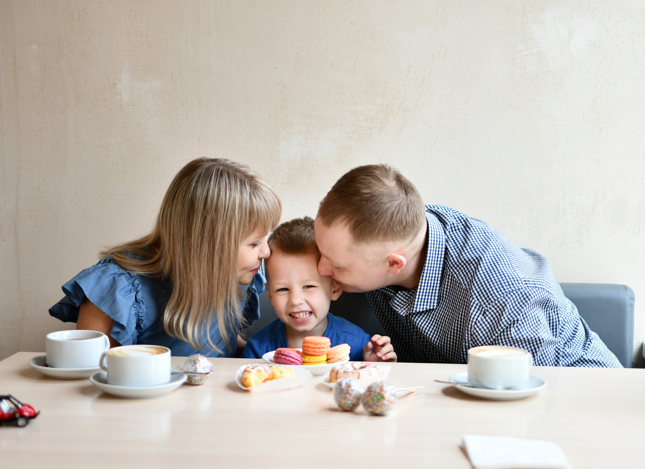 Папа и мама целуют сына