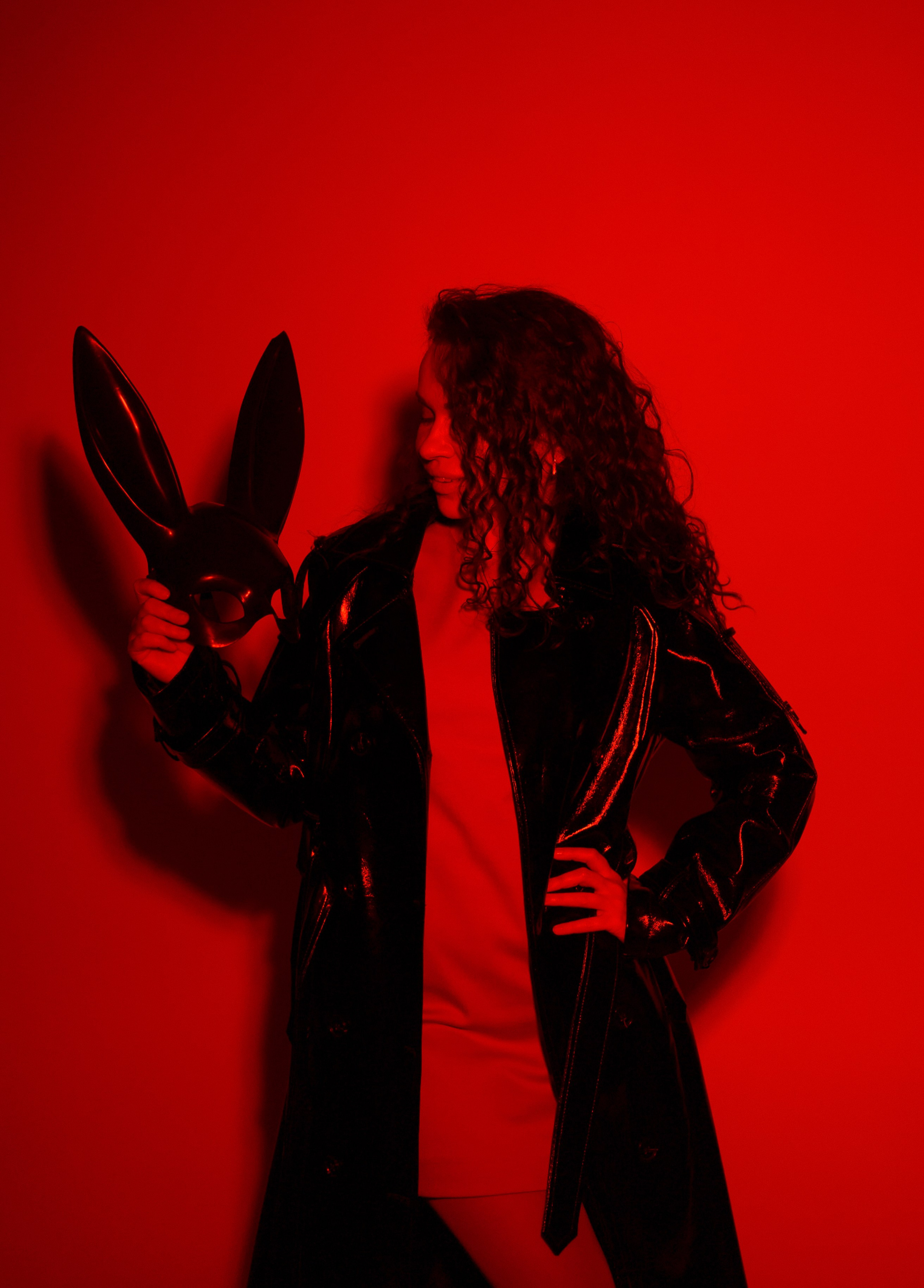 Девушка на красном страстном фоне с маской зайца в студии в Анапе