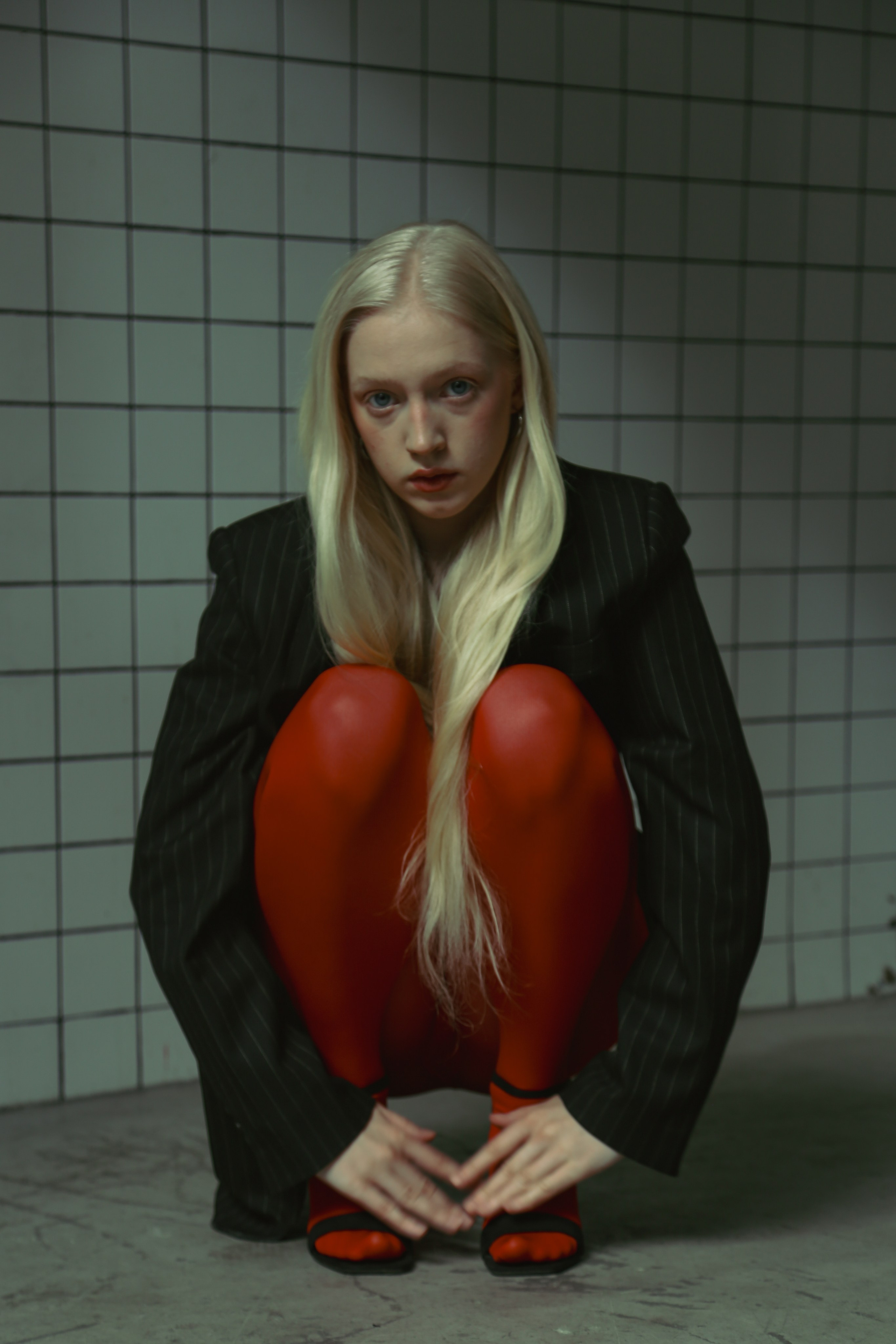 Девушка модель блондинка в пиджаке и красных колготках