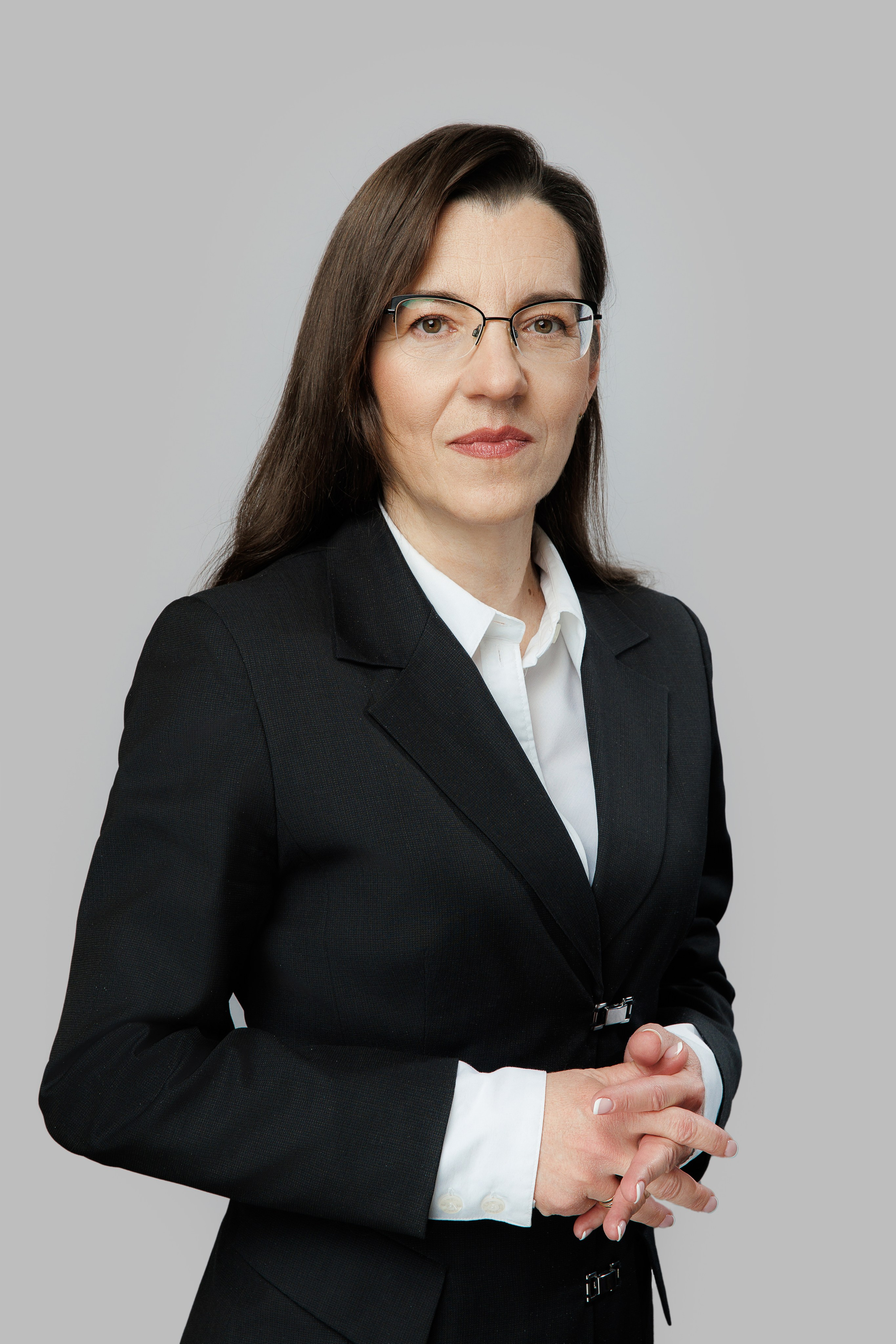 Деловой портрет девушки в пиджаке на сером фоне