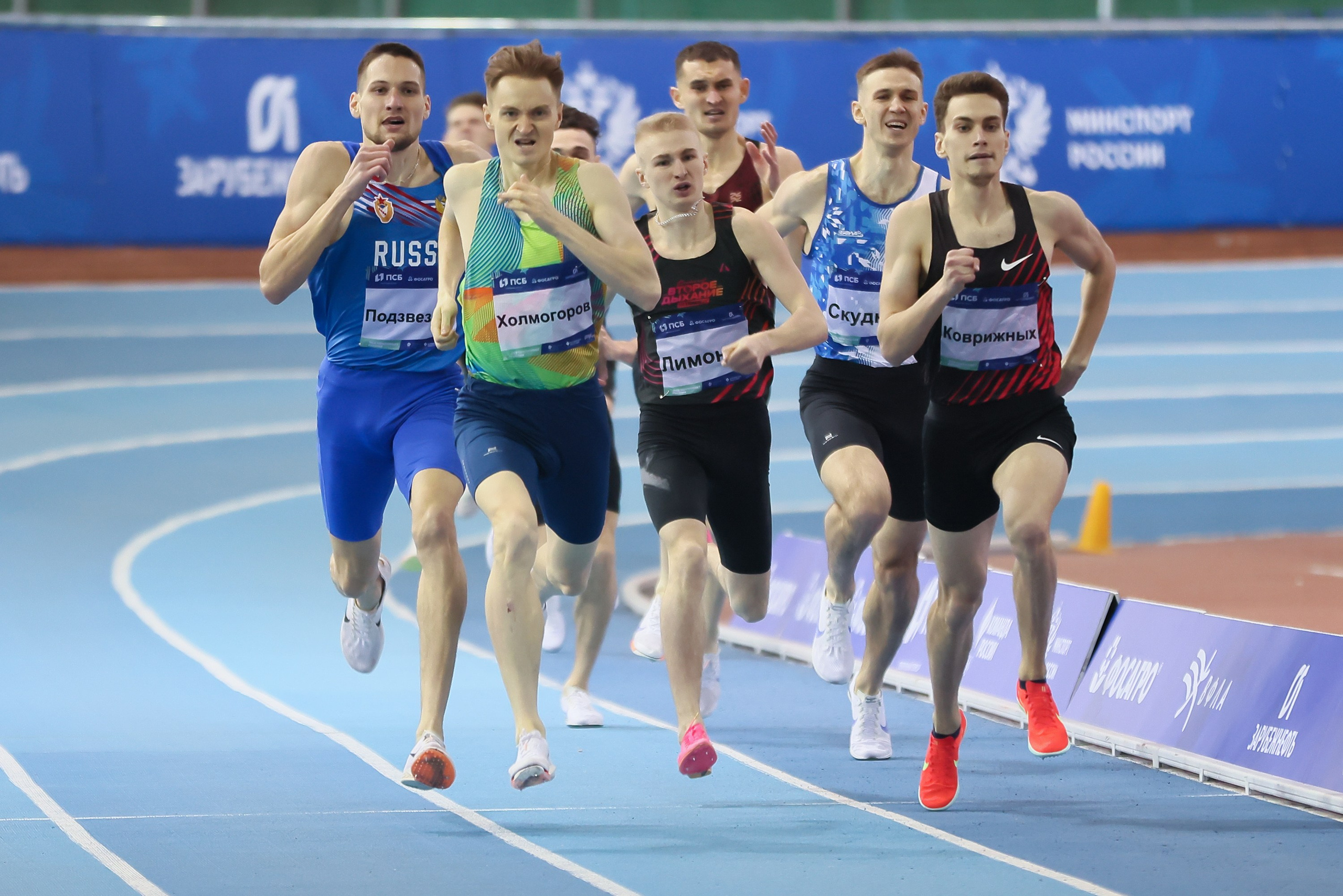 Финиш бегунов мужчин с яркими эмоциями