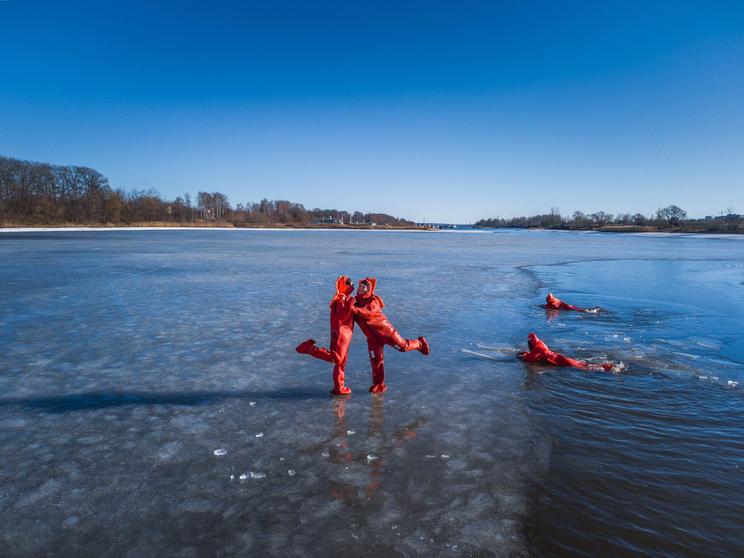 Люди купаются среди льдин, в спасательных оранжевых термо костюмах, айс флоатинг Ярославль