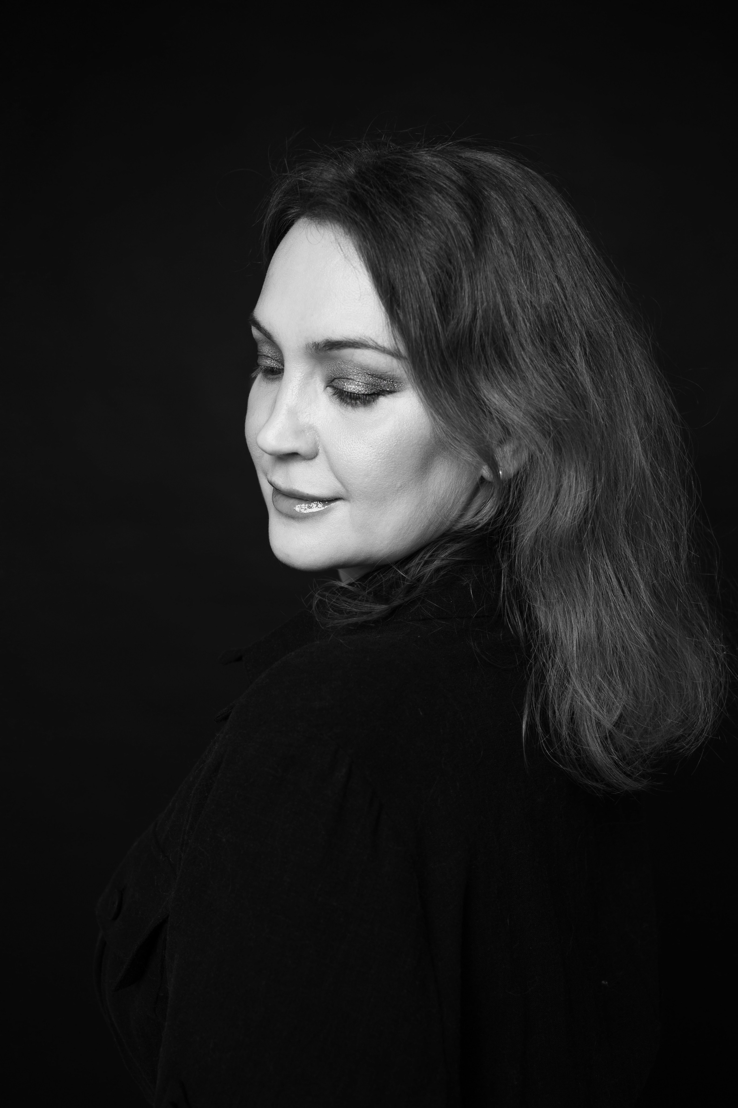 Черно-белый профиль на темном фоне, психологический женский портрет, минимализм в студии Петербург, задумчивое выражение