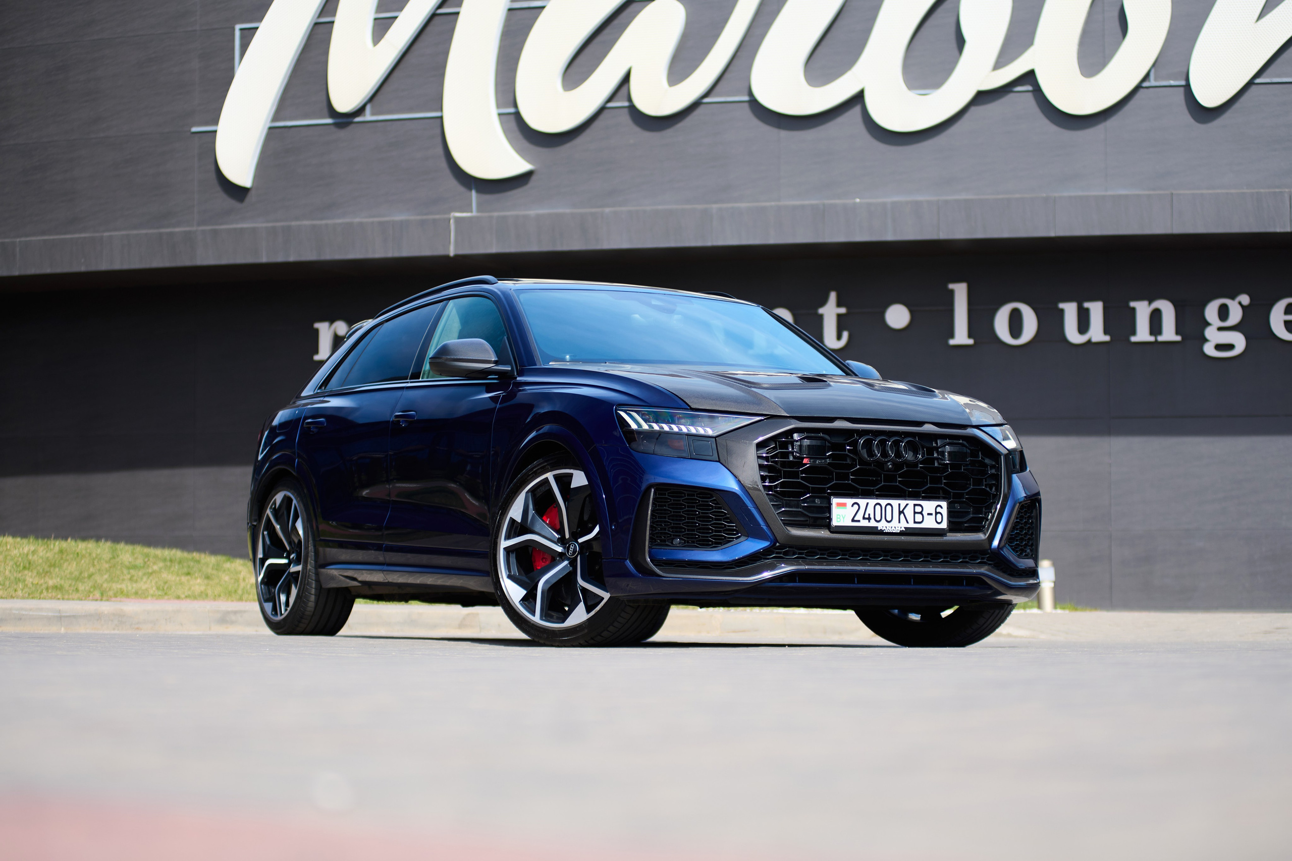 Синий Audi RS Q8 на фоне Maroon restaurant lounge