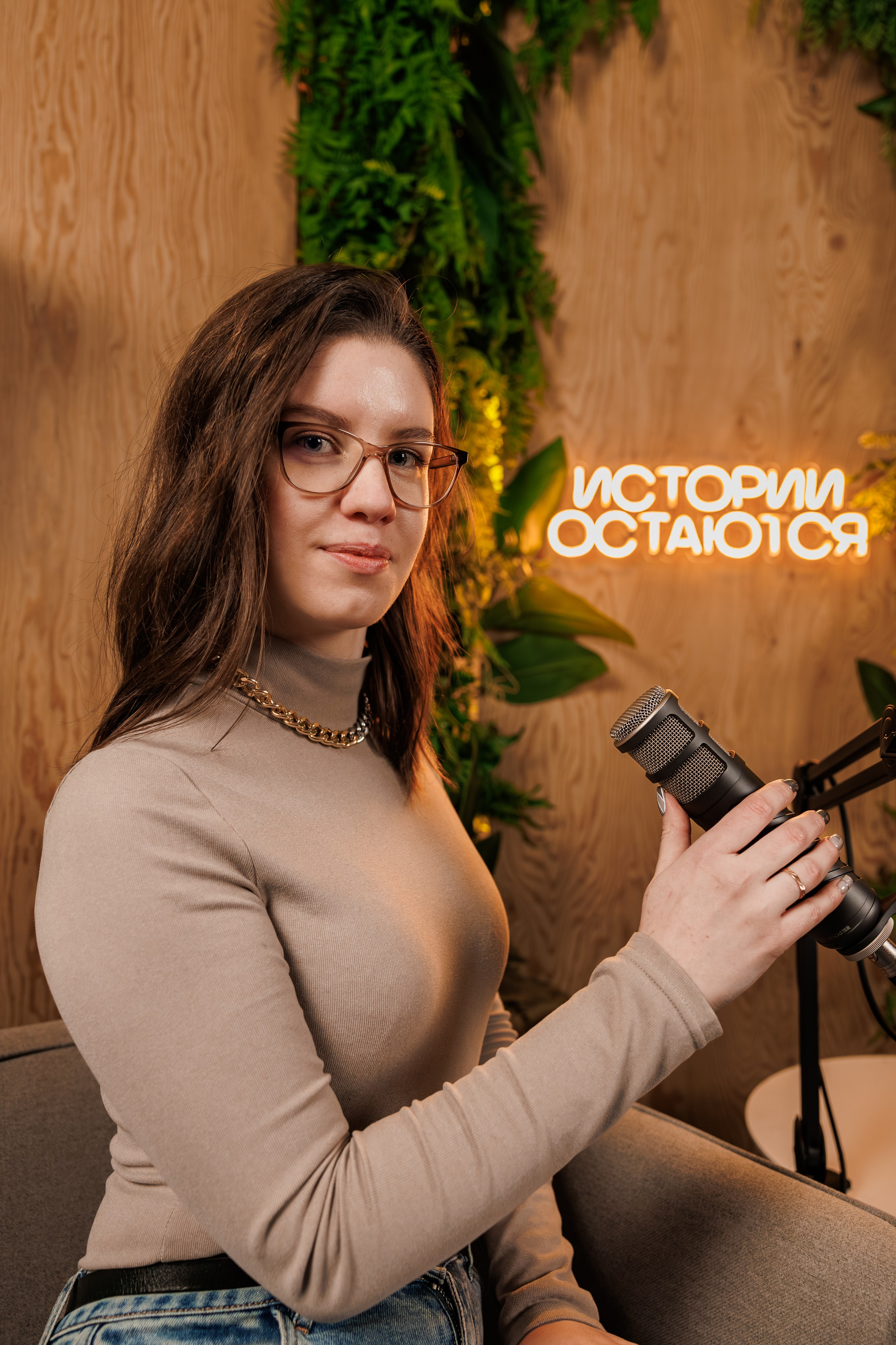 Контент-съемка для эксперта в Хабаровске: девушка с микрофоном в студии на фоне неоновой надписи "Истории остаются". Профессиональный портрет для блога и соцсетей