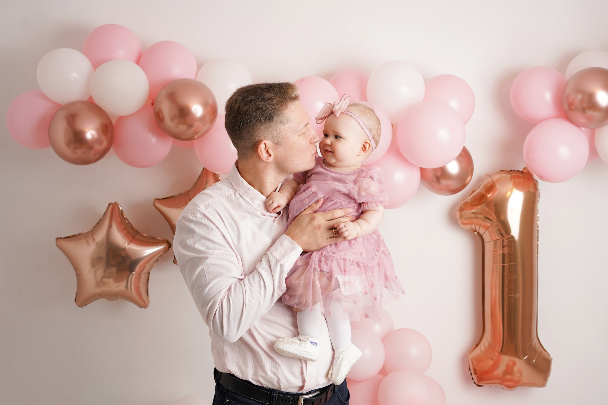 Папа целует свою доченьку и поздравляет ее с Первым годиком.