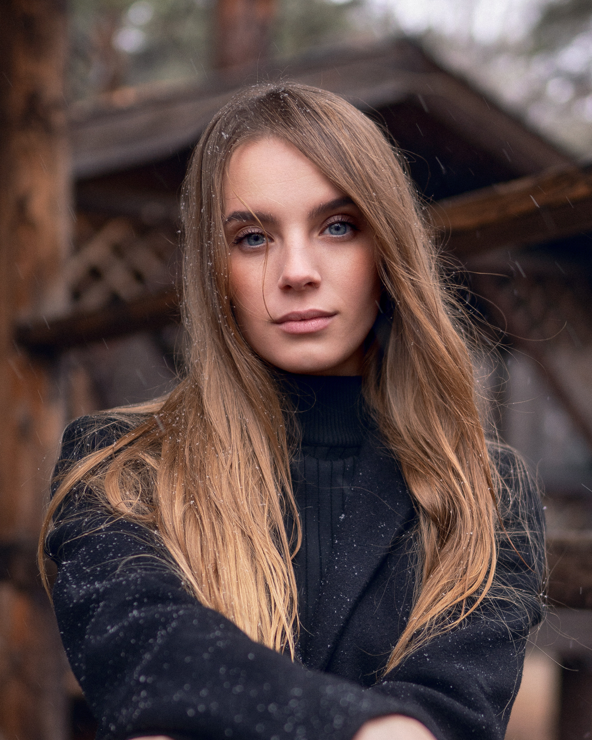 Женский портрет красивой девушки на фоне деревянных строений