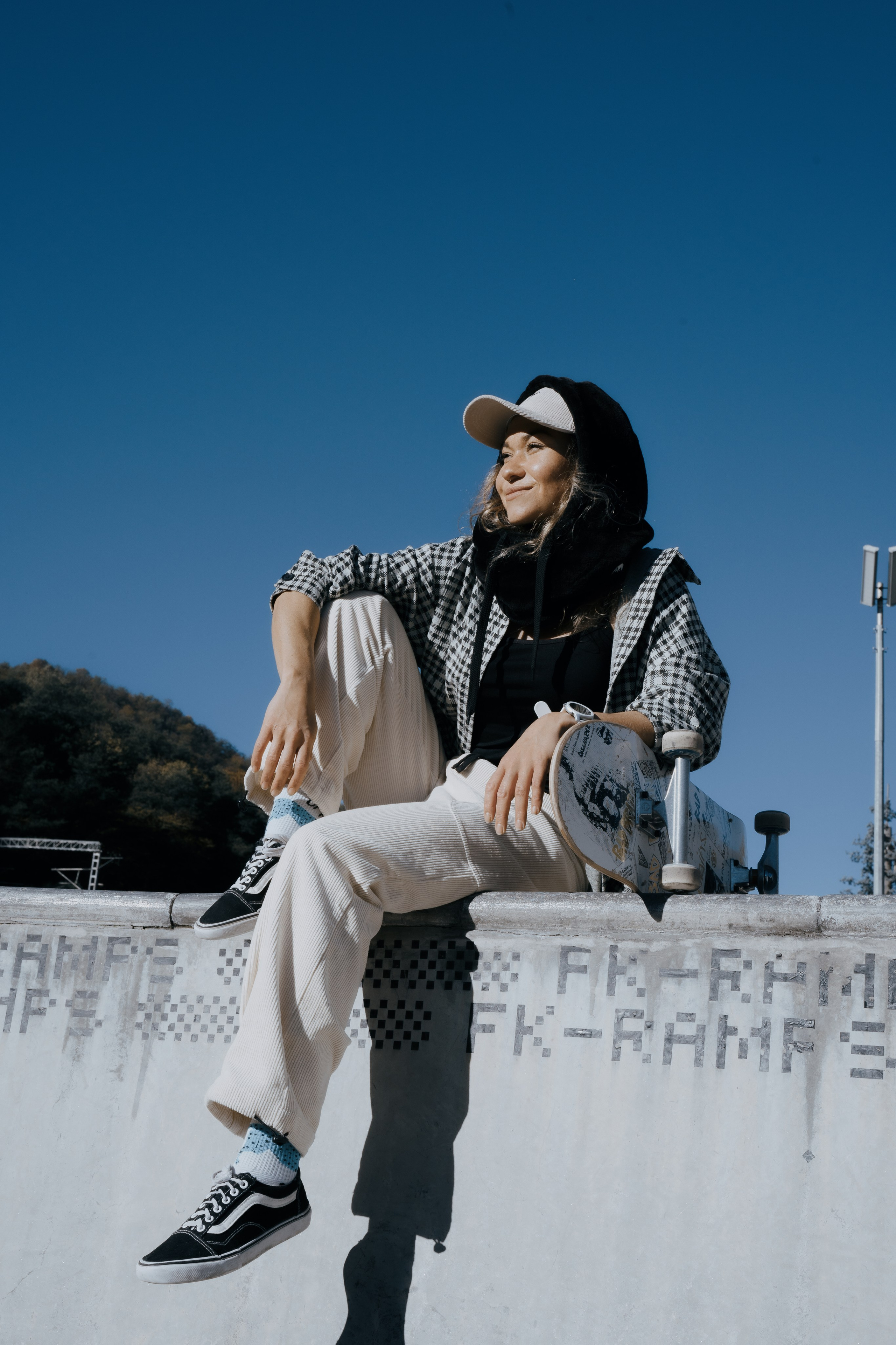 Фотография молодой девушки сидя  на полу в скейт парке 