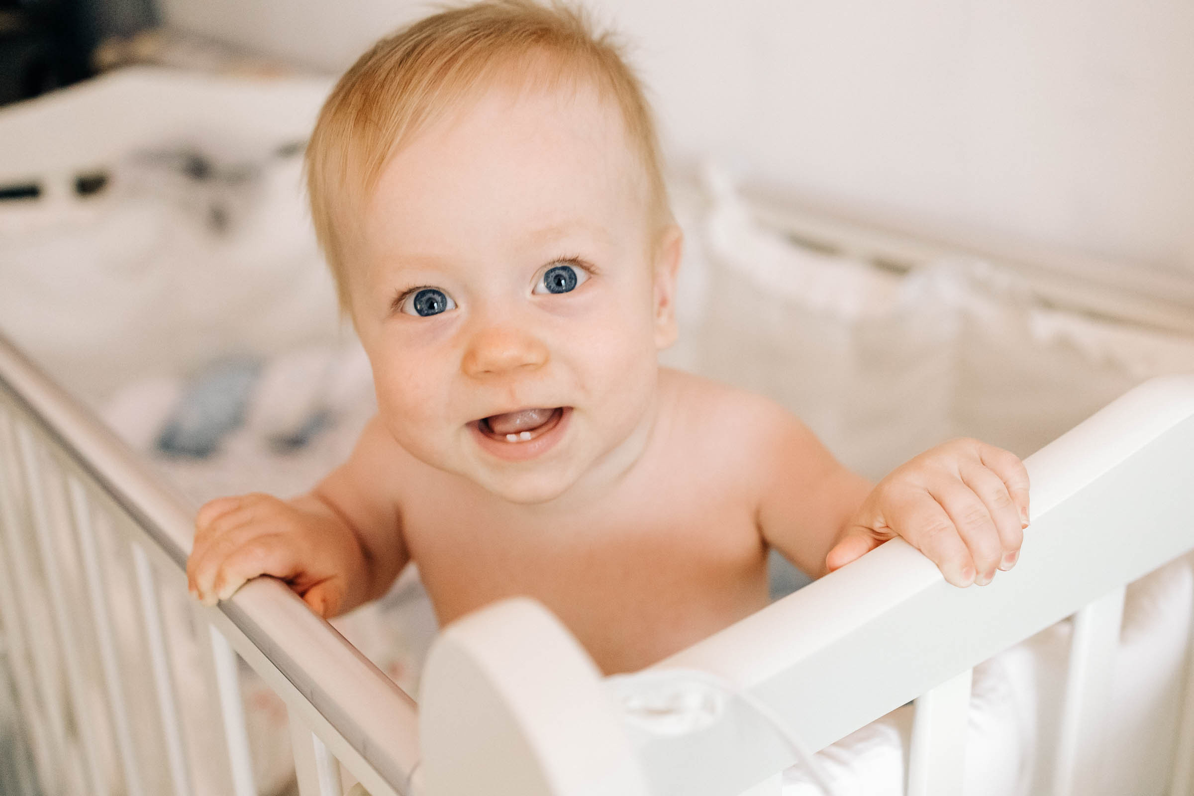 малыш в кроватке улыбается