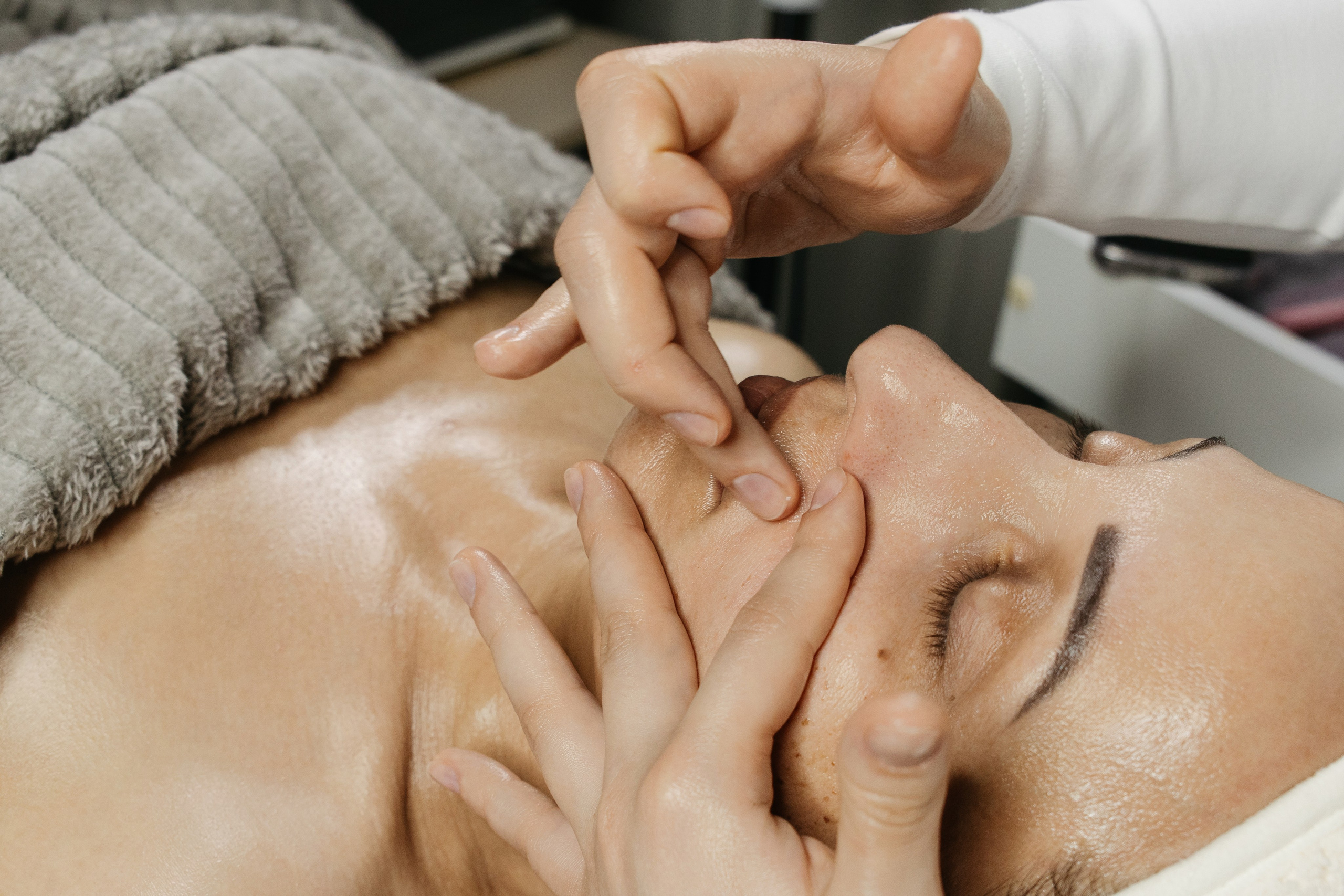 Руки косметолога во время уходовой процедуры, крупный план