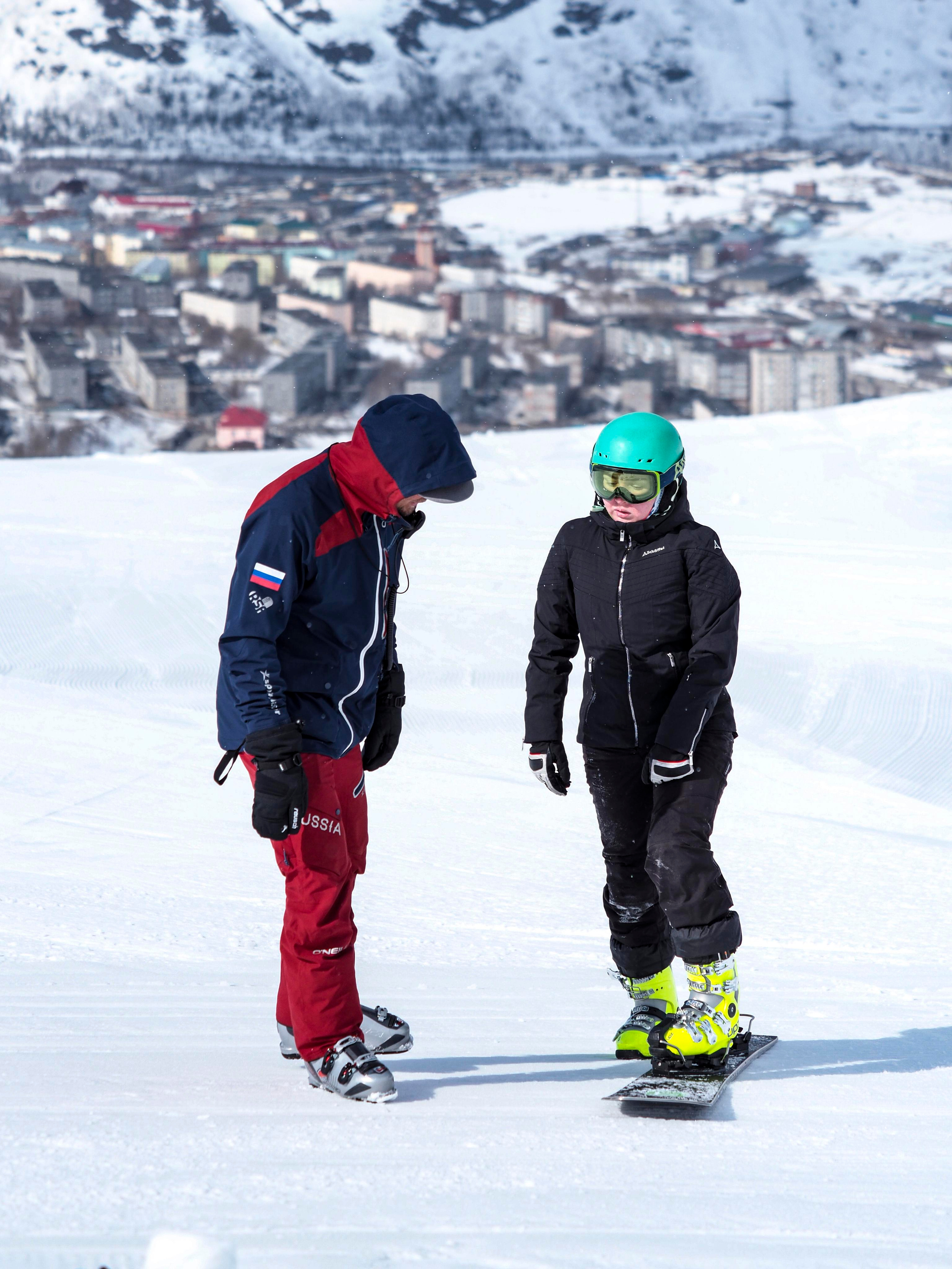 Тренер сборной России по сноуборду делает замечание девушке-сноубордистке на горнолыжном склоне Big Wood на фоне Кировска
