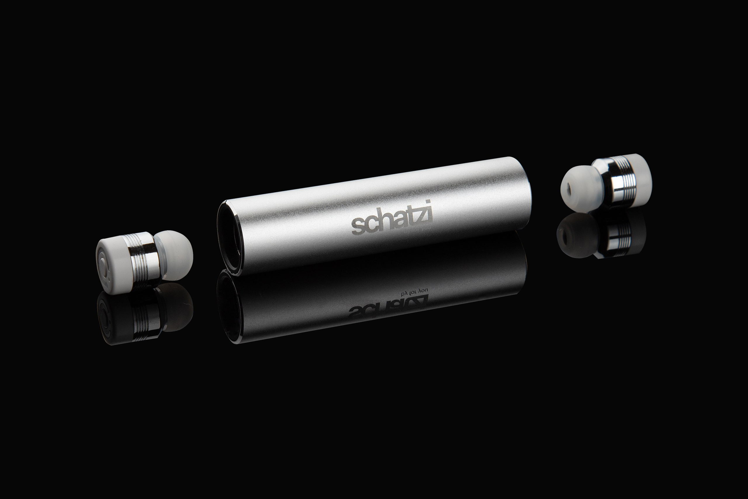 Серебристые беспроводные наушники рядом с кейсом