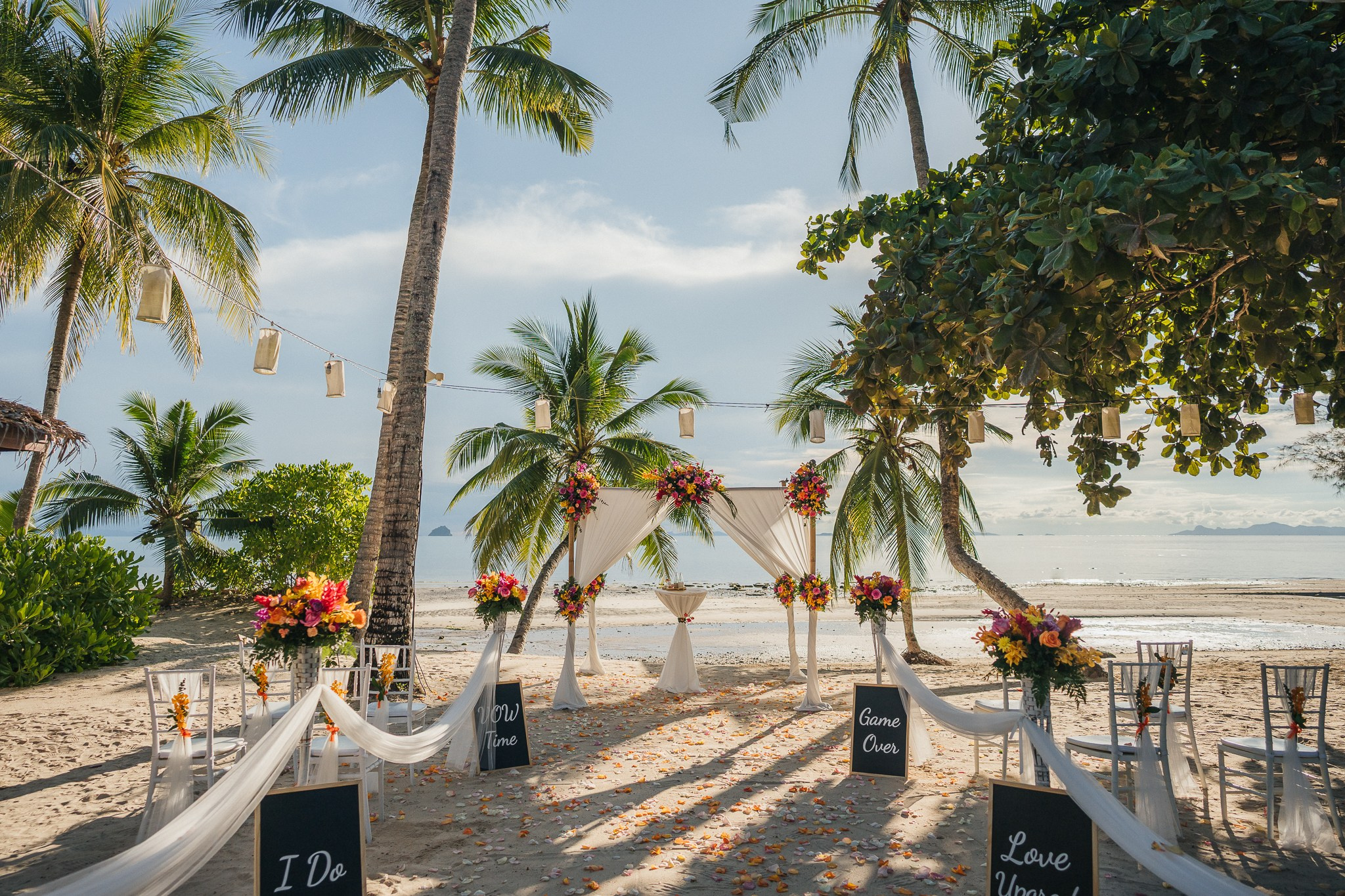 Destination beach wedding in Koh Samui, Thailand with the couple, family members and friends enjoying a tropical wedding ceremony by the sea