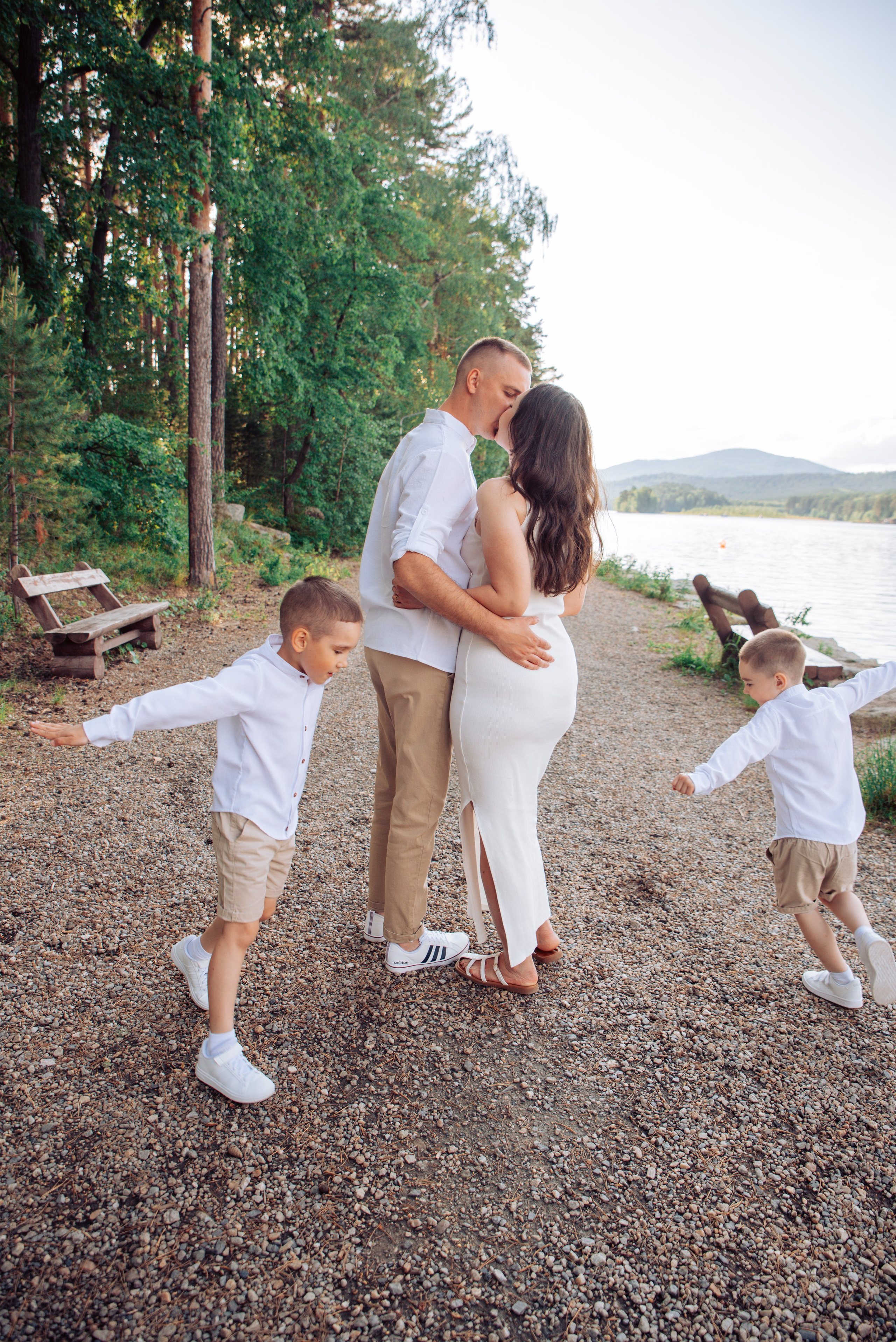 Семейная прогулка летом на берегу озера по пляжу