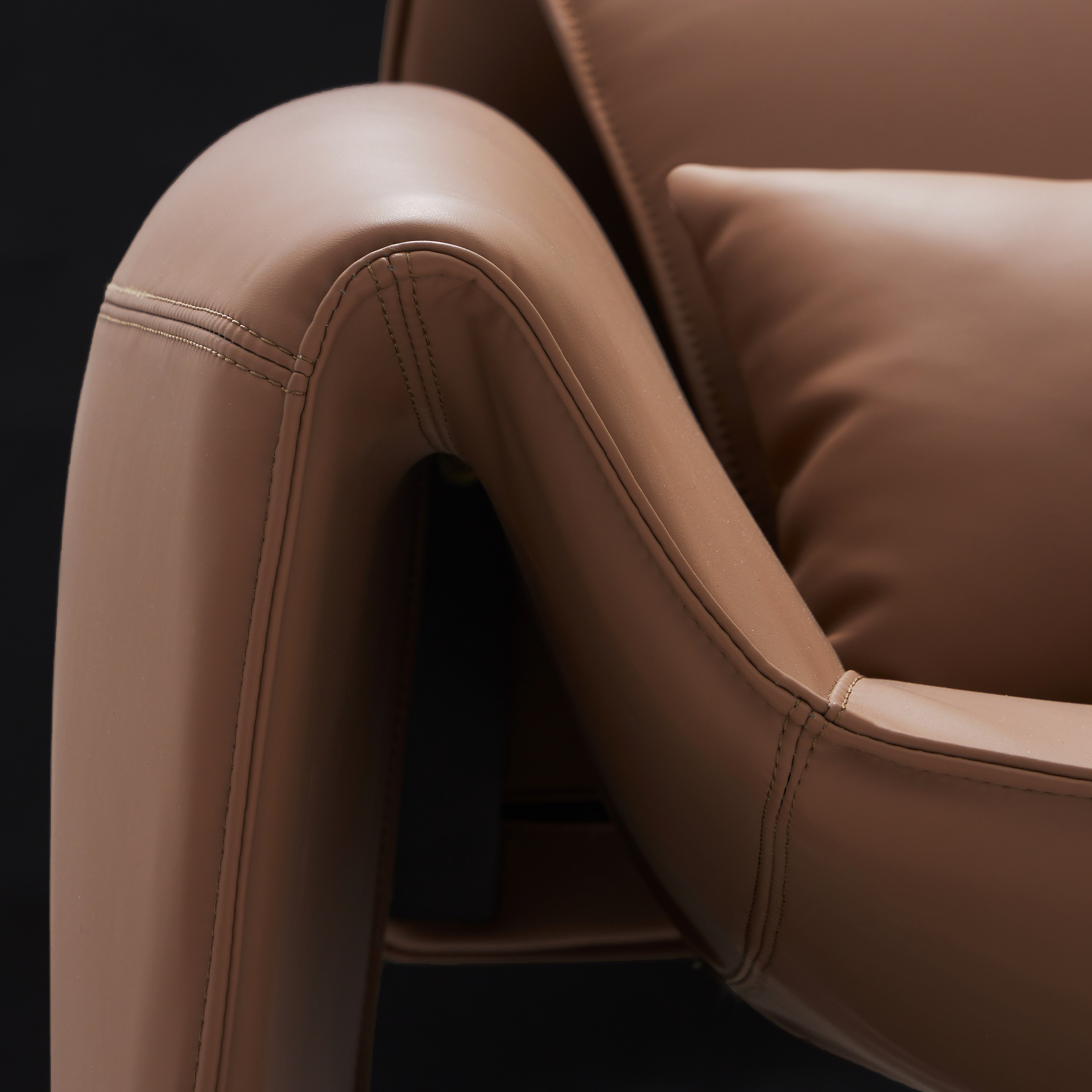 подлокотник кожаного кресла коричневого цвета. 