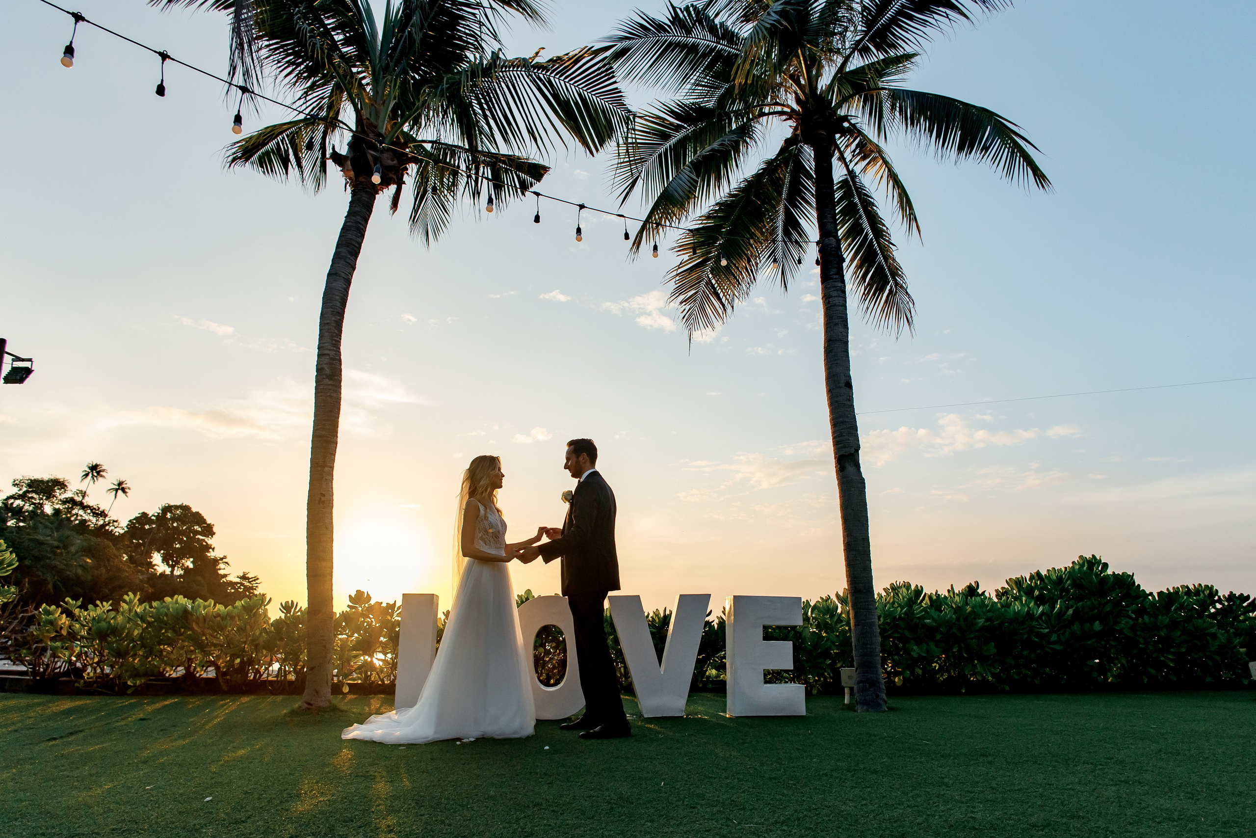 силуэт пары на фоне пальм и заката 
