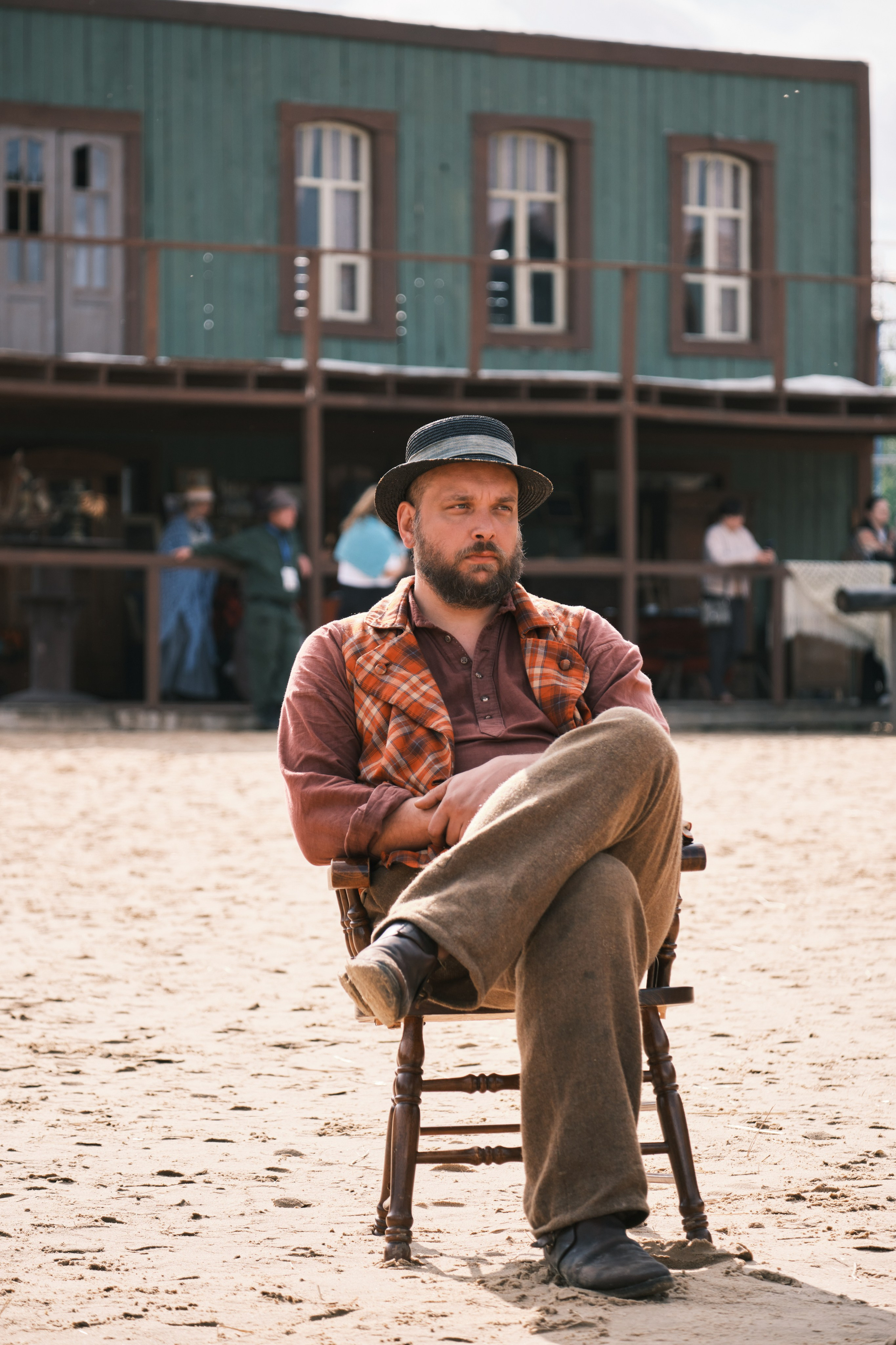 Мужчина сидит на стуле в ковбойском городке 