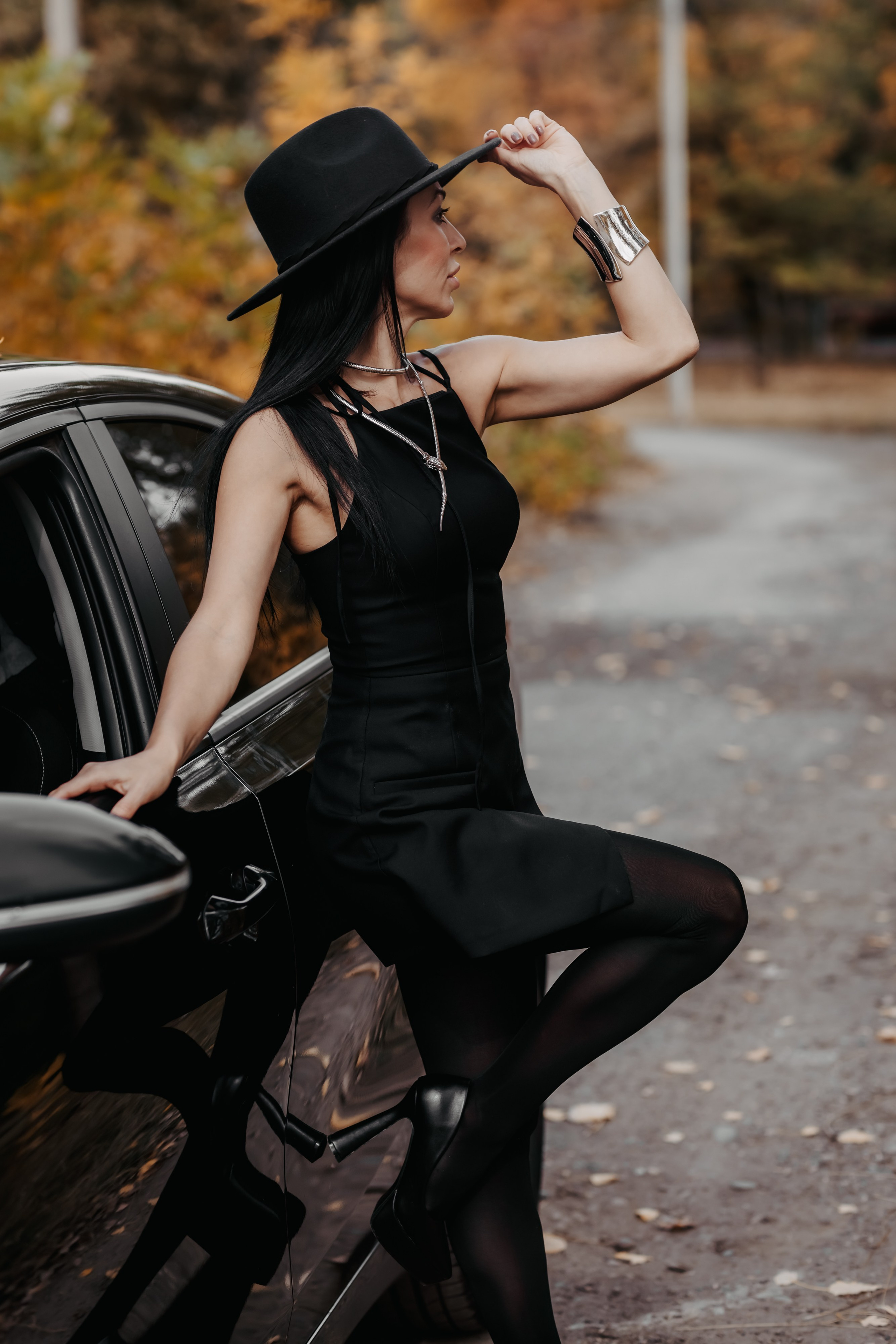 Классическая красота: девушка у машины на фоне осеннего пейзажа Невинномысска