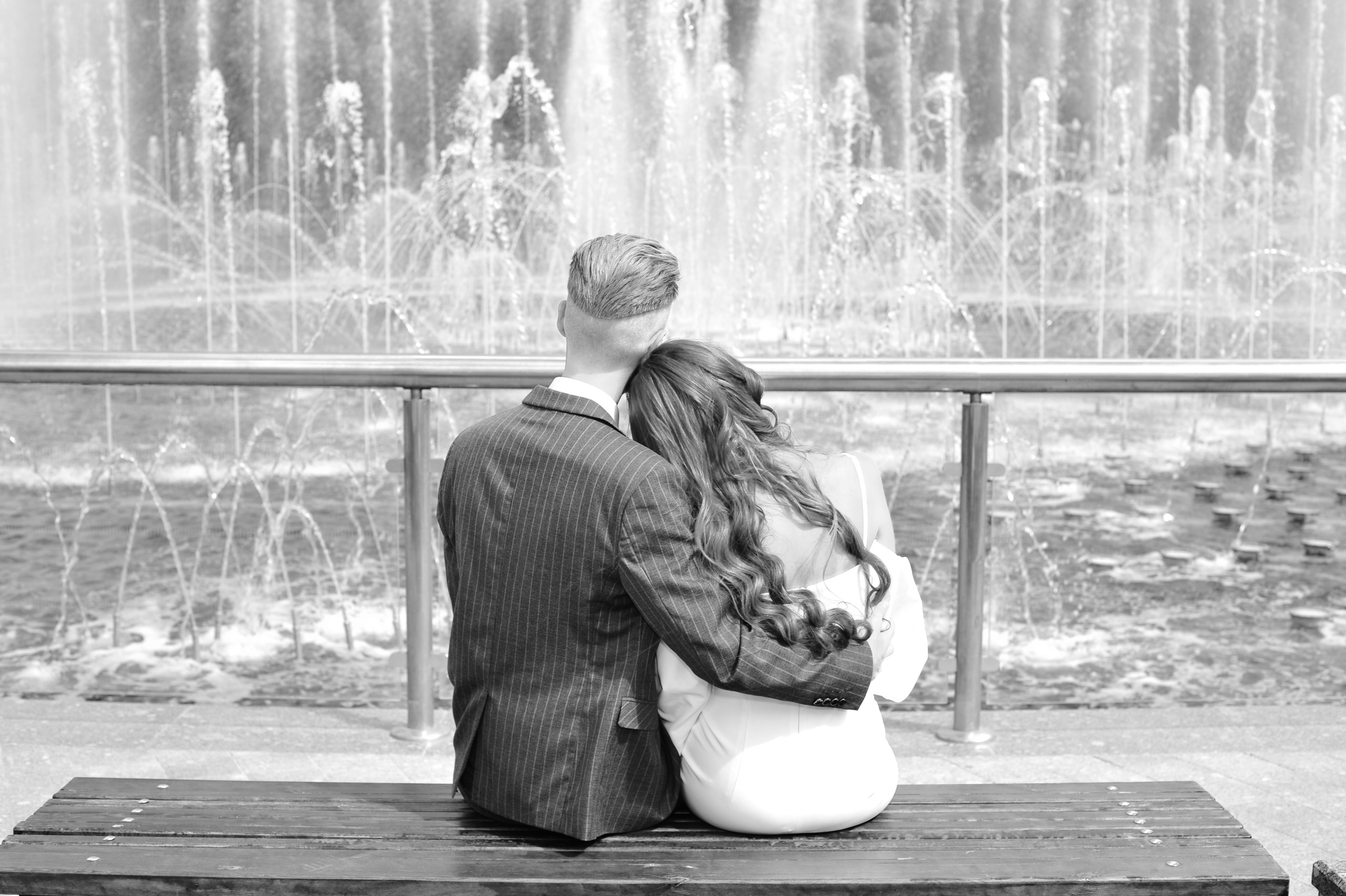 Свадьба в Царицыно летом, молодожены сидят на лавочке и смотрят на струи фонтана, чёрно-белая фотография