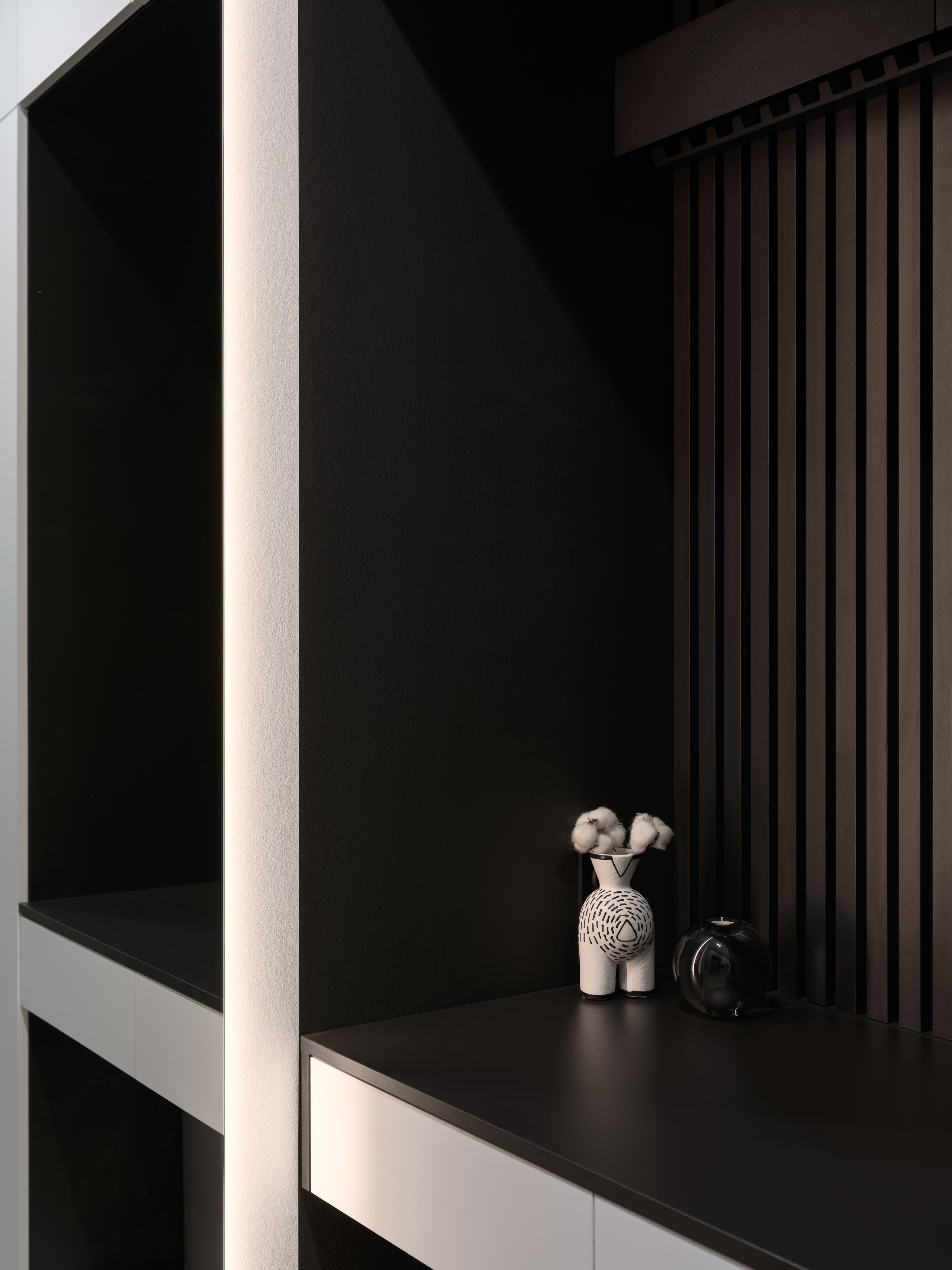 Современный интерьер с декоративной вазой и аксессуарами на черной полке, акцентными панелями и встроенной подсветкой. Автор проекта — дизайнеры Евгения Княжева и Владлена Привалова, фотограф Сергей Денисенко