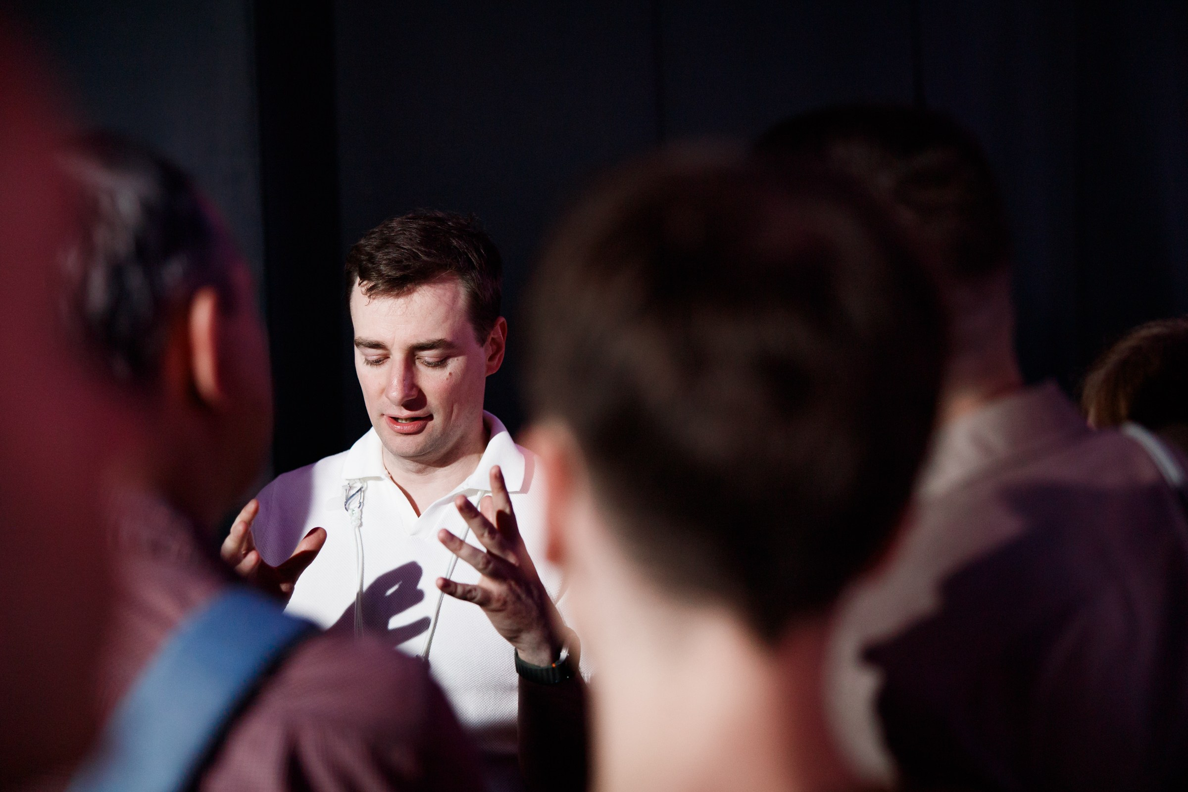 Группа людей в размытом фокусе обсуждает проект, репортажная съемка сообщества программистов.