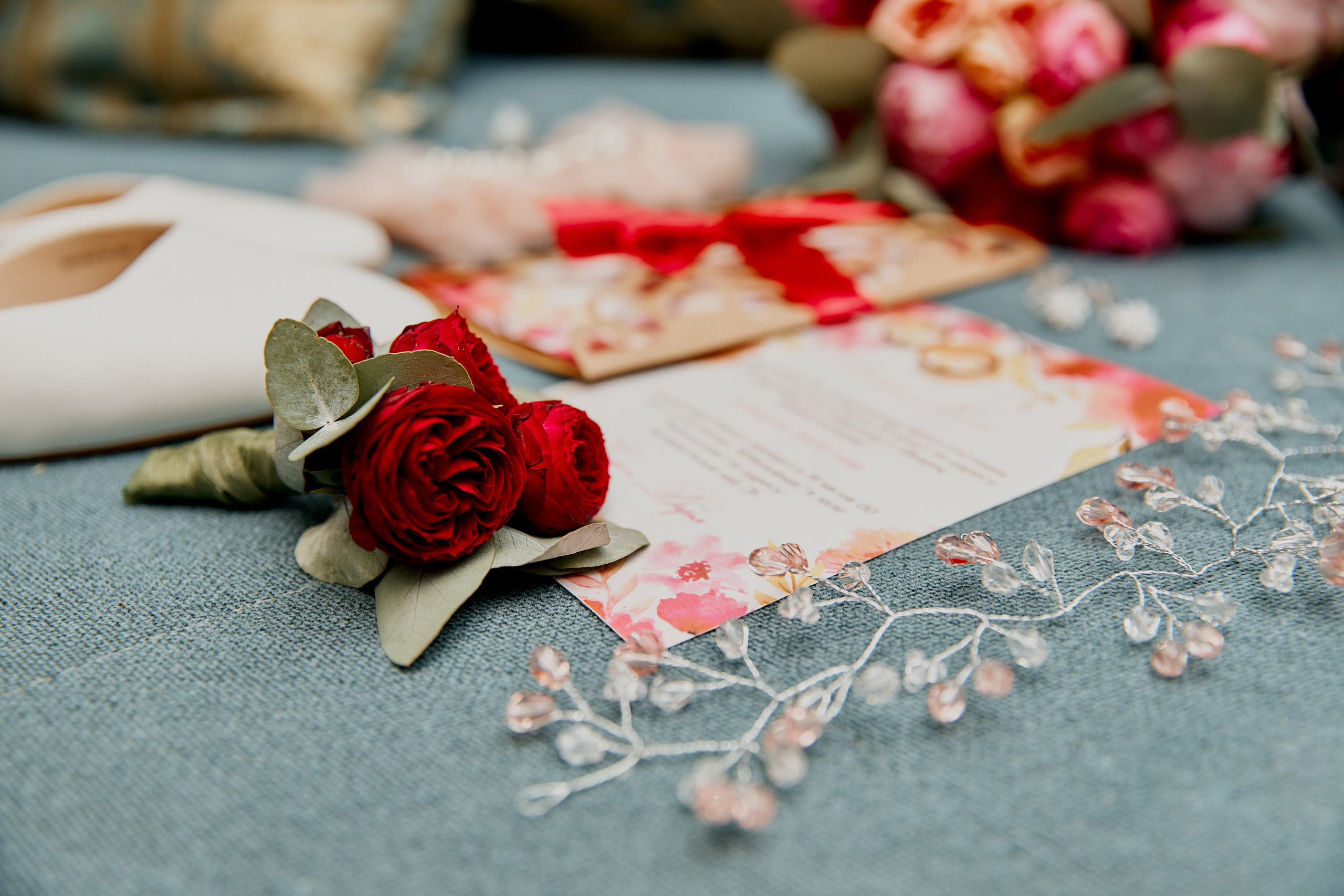 бутоньерка жениха лежит на пригласительных на свадьбу